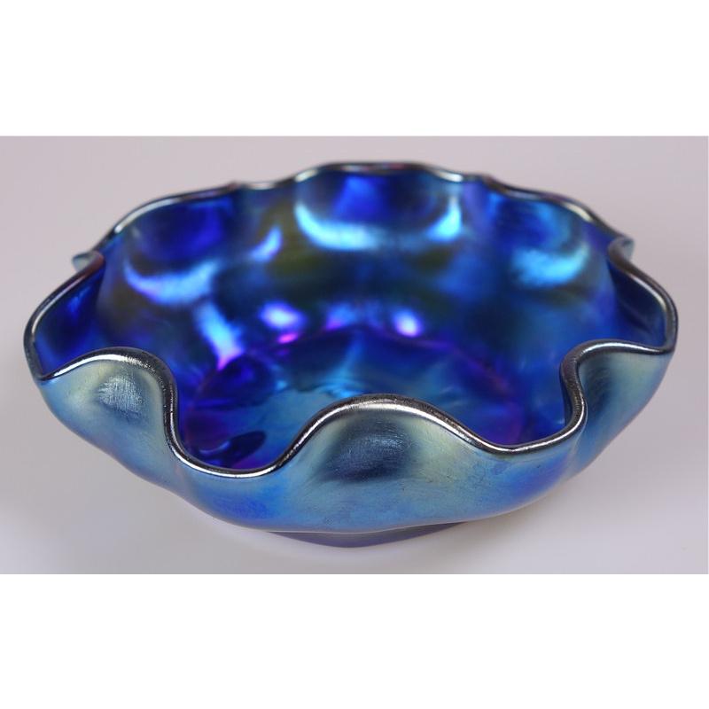 Offering this rare Louis Comfort Tiffany blue Favrile iridescent art glass bowl. This blue finger or berry bowl features a undulating ribbon design lip and is signed on the underneath 