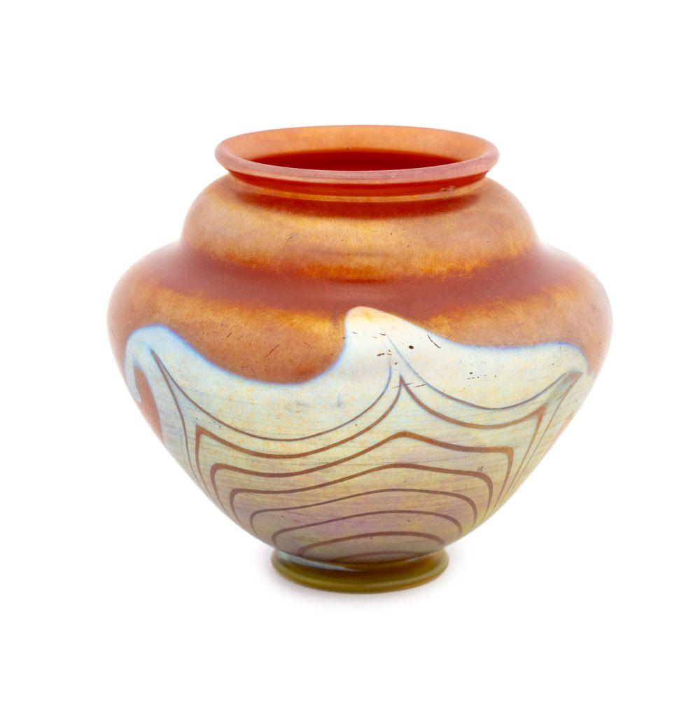 Louis Comfort Tiffany Red Favrile Glass Vase, circa 1917, of gently waisted ovoid form with flaring rim above a circular foot, with pulled feathering in silvery blue to purple favrile, inscribed 