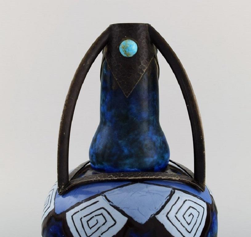 Louis Dage (1885 - 1961), French potter. 
Large Art Deco vase in glazed ceramics and wrought iron mounting with inlaid turquoises. 1920s.
Measures: 29 x 20 cm.
In excellent condition.
Signed.
