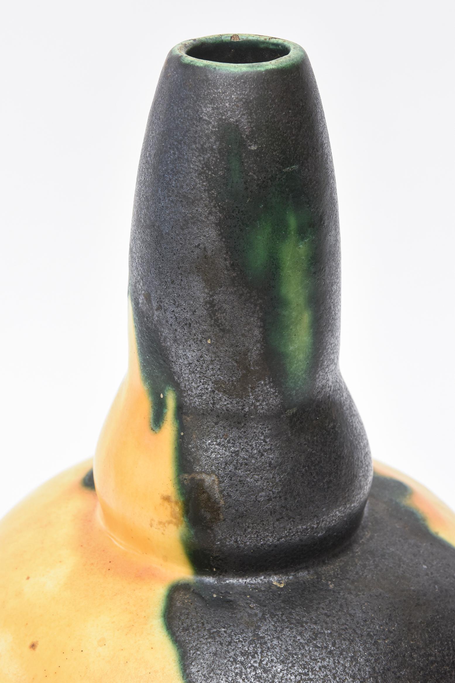 This most unusual French signed Louis Dage glazed ceramic gourd vessel has a great color palette to it. Drippings of black glaze and green glaze segments pour over the yellow background in a beautiful erratic pattern. This is from the 1960s or early