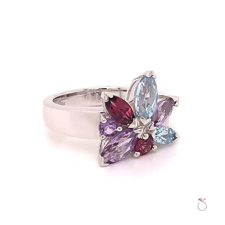French Designer Louis Feraud Aquamarine, Amethyst and Garnet Ring in 18k white gold. This beautifully designed ring features a gorgeous cluster of gemstones different shapes and colors. The gemstones are marquise and round brilliant cuts and have