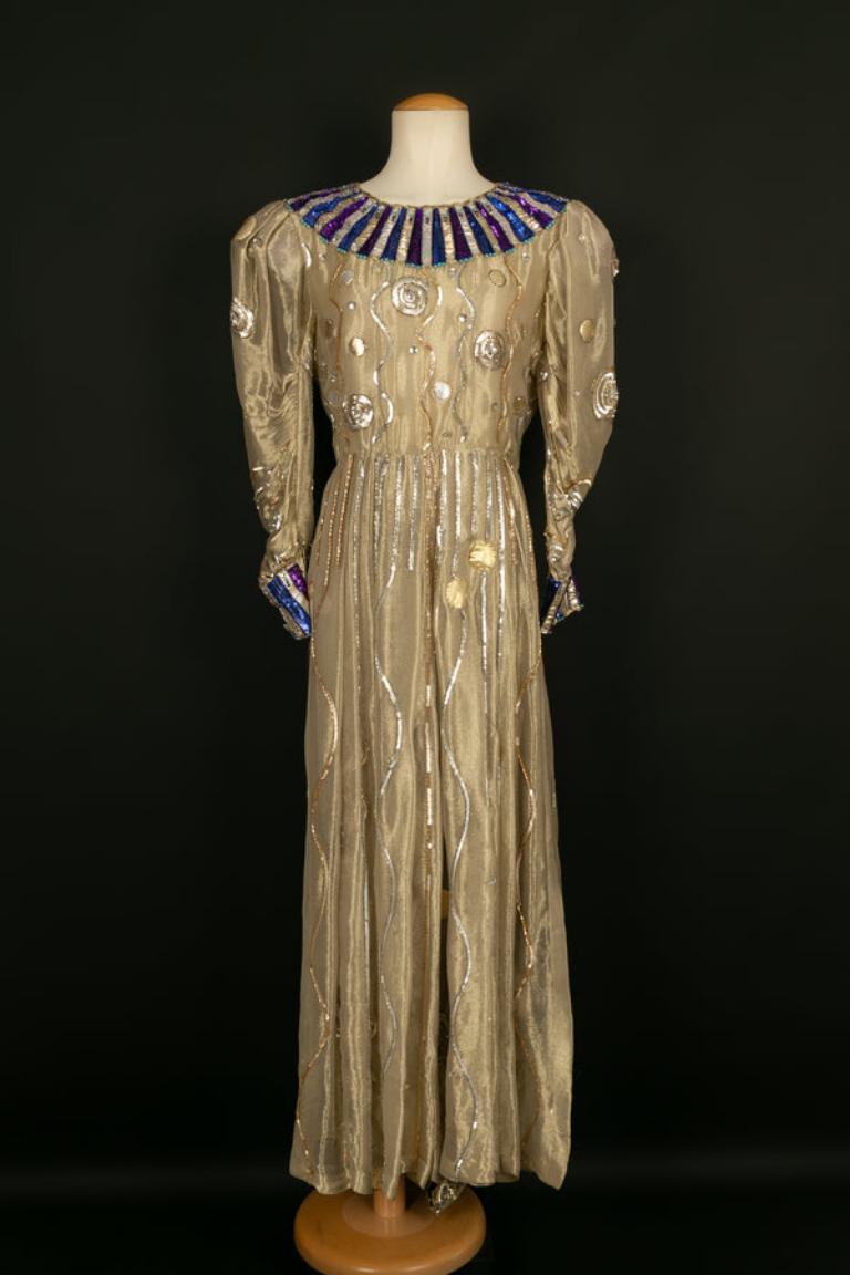 Louis Féraud - Haute Couture set composed of a dress and pants in lamé embroidered with sequins, pearls, and cabochons. No size nor composition label, it fits a 38FR. Fall-Winter 1982/1983 Collection. The lamé of the dress is worn in several