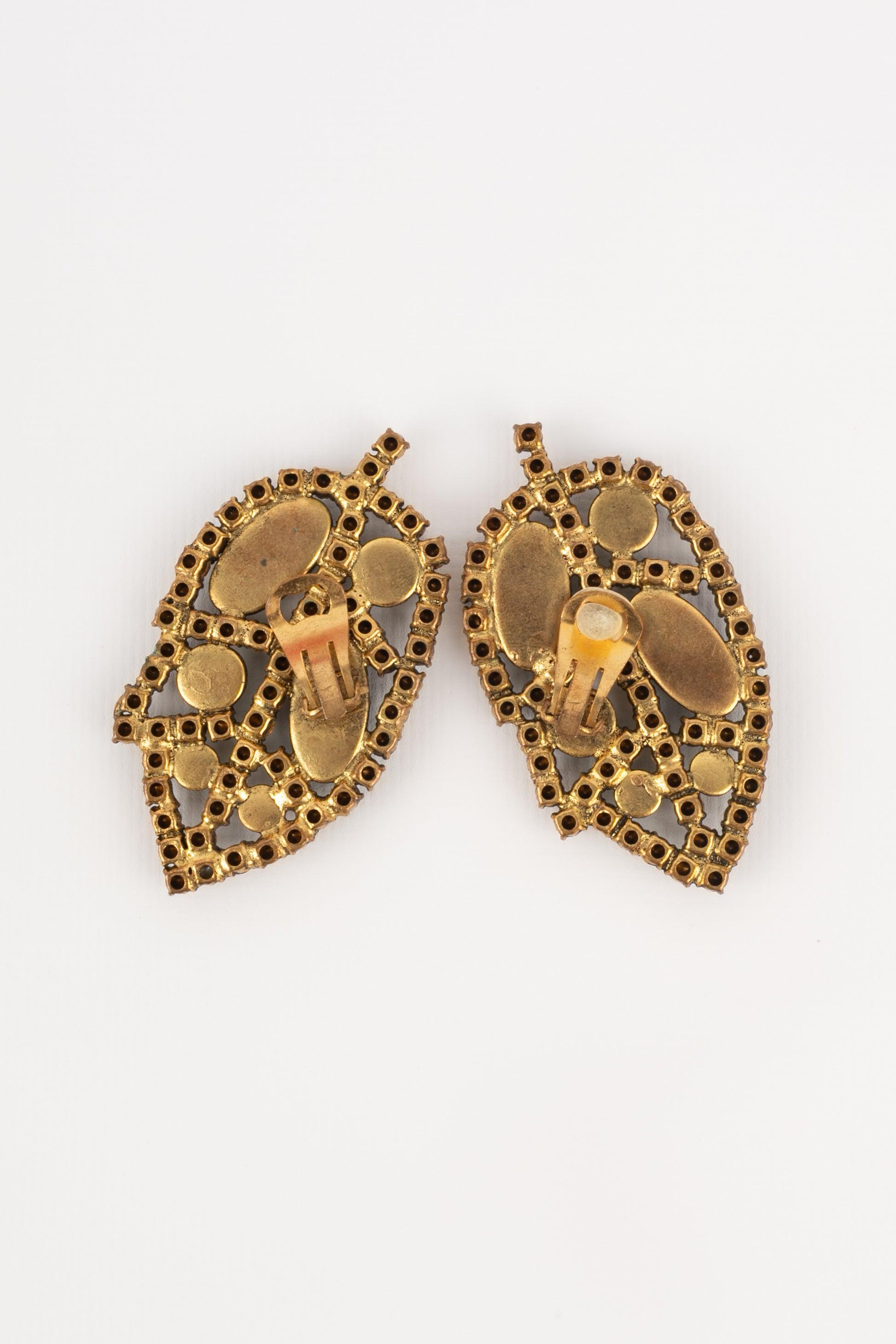 Louis Féraud - Boucles d'oreilles ajourées en métal doré serties de strass et de cabochons en pâte de verre. 1980 circa Collectional.

Informations complémentaires :
Condit : Bon état
Dimensions : Hauteur : 7 cm
Période : 20ème siècle

Référence du