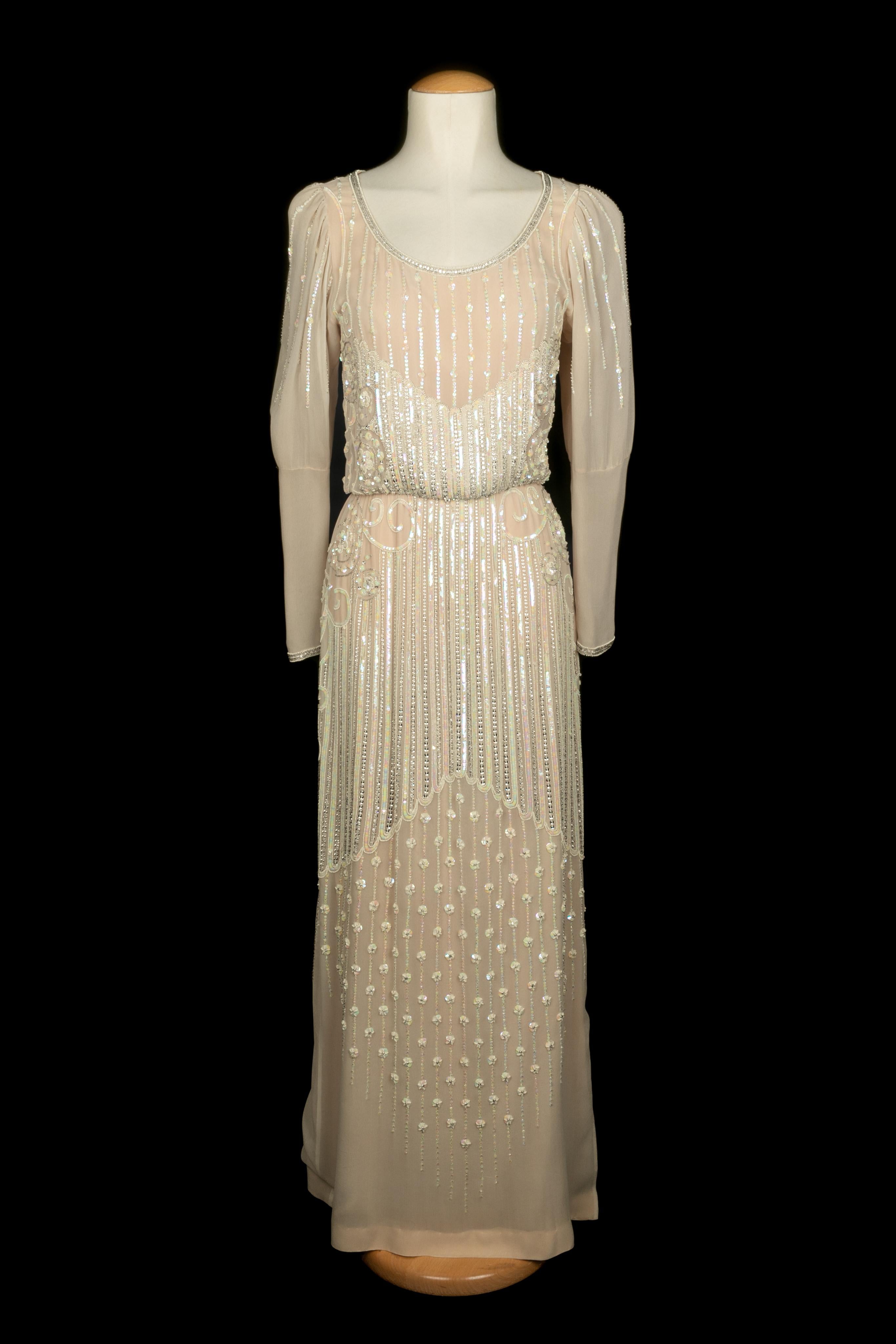 LOUIS FERAUD - (Made in France) Elfenbeinfarbenes Abendkleid aus Musselin, bestickt mit Perlen und Pailletten. Zusammensetzung und Größe Etiketten fehlen, es passt ein 38FR. Eine Haute Couture Collection'S um 1978.

Bedingung:
Sehr guter