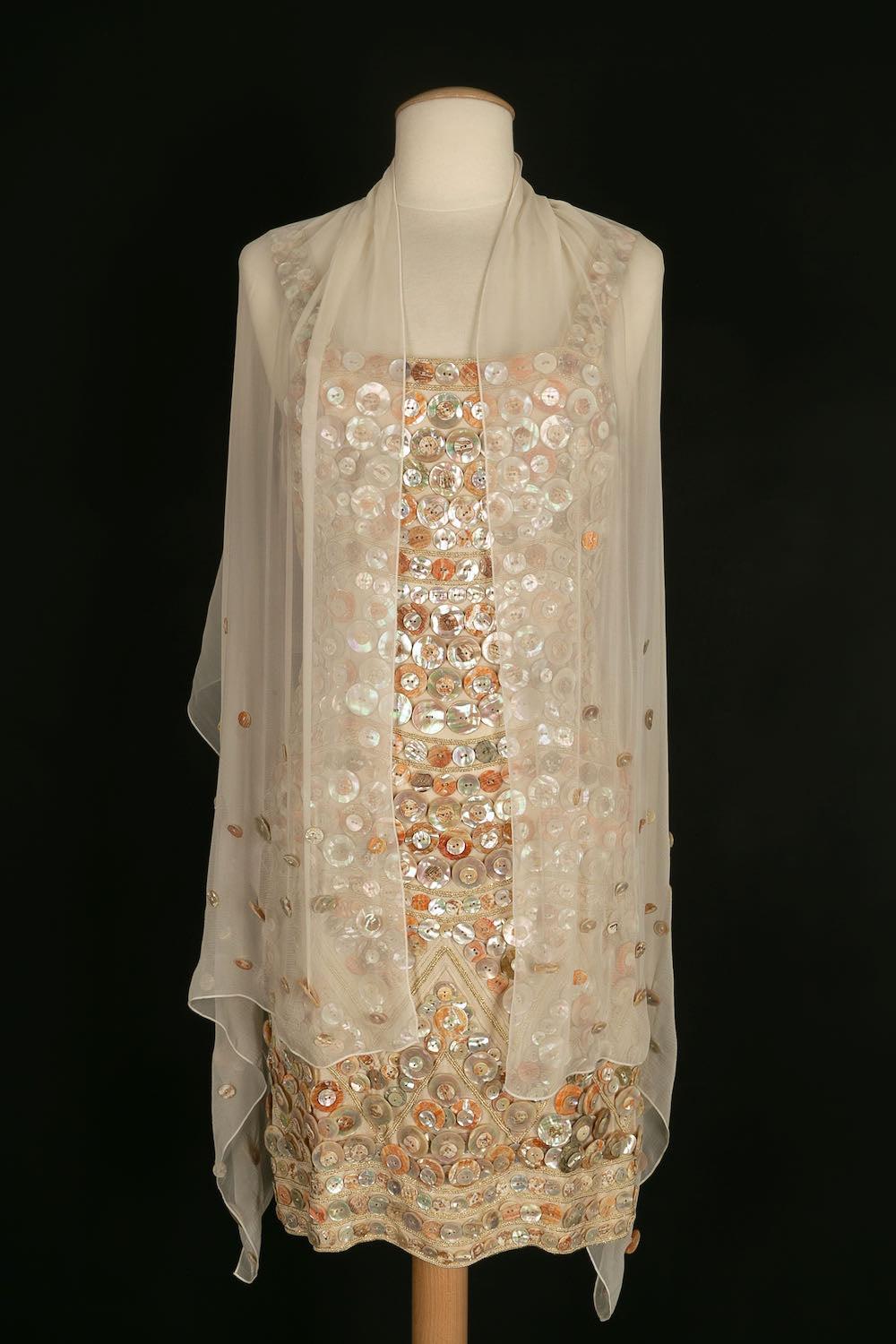 Louis Féraud -Satin dress embroidered with mother of pearl buttons. It is accompanied by a beige muslin stole also embroidered. 
No size indicated, it corresponds to a 34FR/36FR. 
Collection 