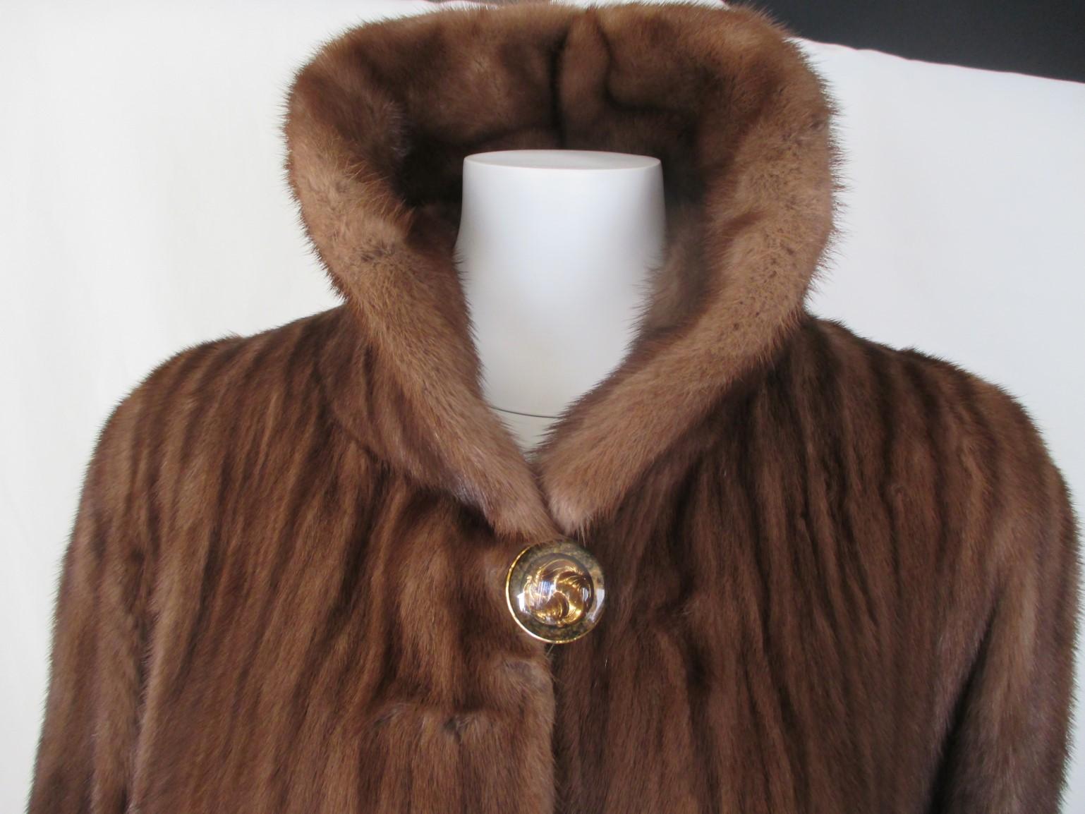 This flared 3/4 length chestnut brown mink coat is made of quality fur with 1 button at the collar, 3 closing hooks, 2 pockets and 1 inside pocket.
Designer: Louis Feraud
These coats are rare to find!

Size fits as medium/large
The measurements are;