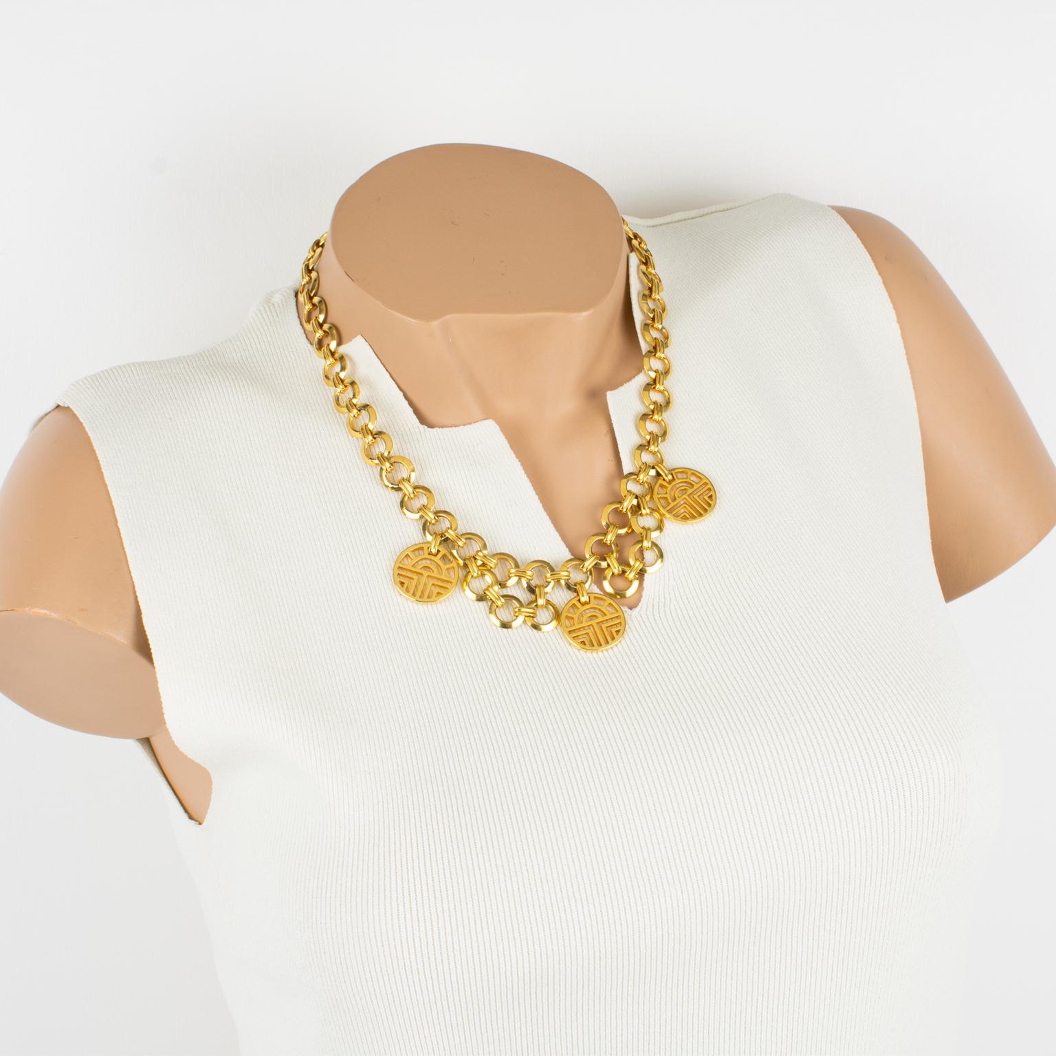 Diese elegante Louis Feraud Paris Halskette hat eine romantische Kettenform mit vergoldeten, verschnörkelten, ikonischen Markenlogo-Anhängern. Die Halskette wird mit einem Karabinerverschluss und einer zusätzlichen Kette geschlossen, wodurch die