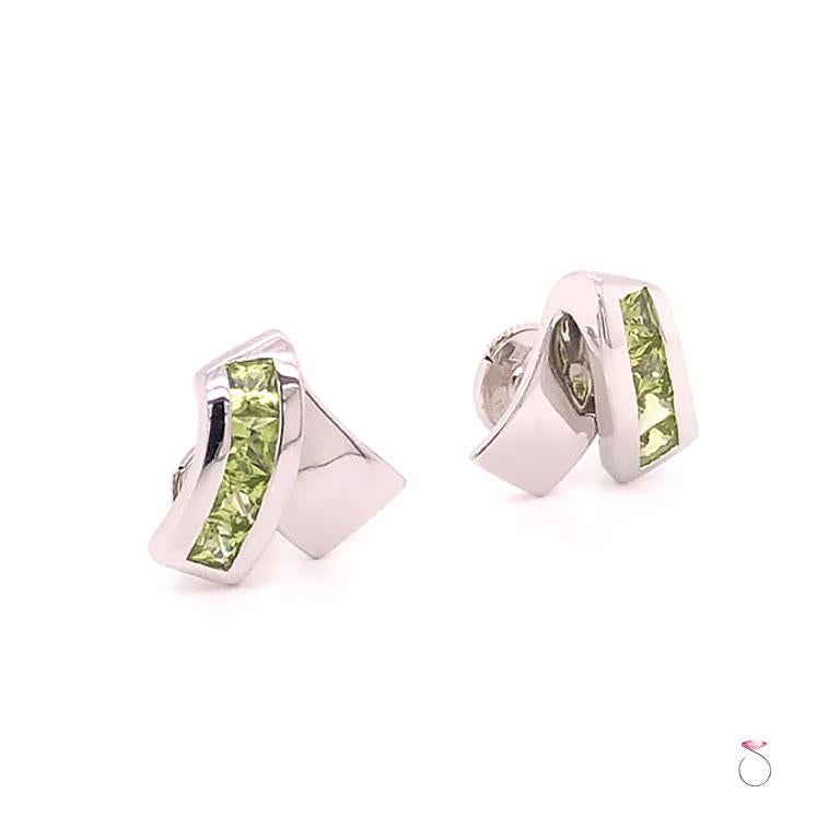 French Designer Louis Feraud Peridot stud earrings in 18k white gold. These earrings have a unique inverted V design. The beautifully designed earrings features four (4) square cut green peridots set in a channel on one side of the inverted V