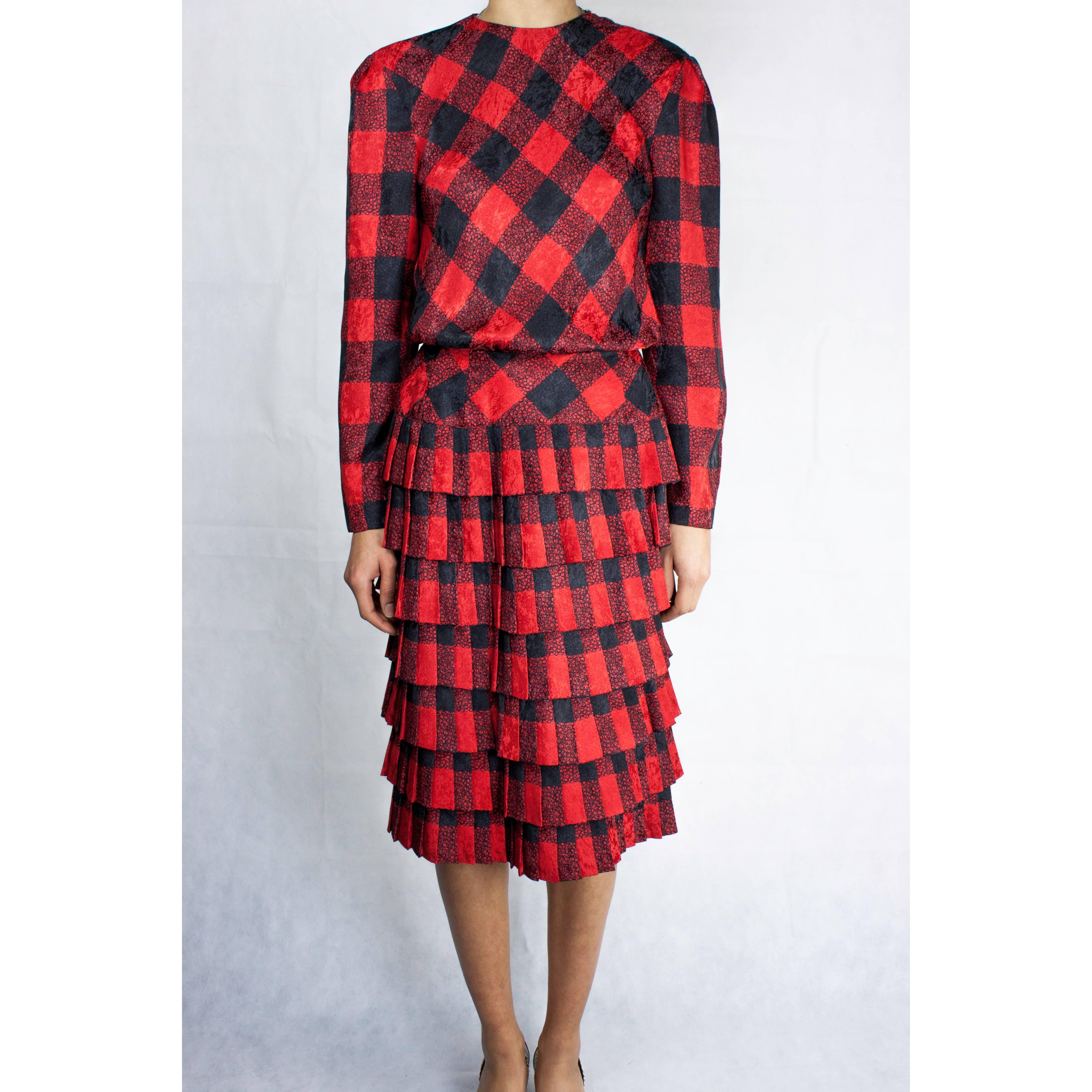 
This Louis Feraud dress is constructed from a silk-like moiré polyester material. Worn with a patten leather belt.Featuring a round neckline, long sleeves and fitted bodice. The fully lined skirt is adorned with layers of pleated ruffles. Fastening