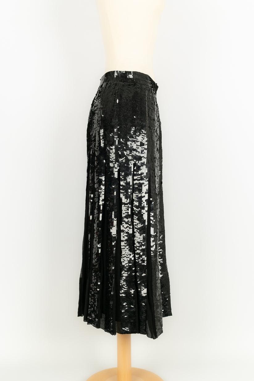 Louis Féraud - (Made in Germany) Black skirt with sequins dating from the 1980s. It is pleated on the lower part revealing silk chiffon panels. Size 40FR.

Additional information: 
Dimensions: Size: 39 cm, Length: 84 cm
Condition: Very good