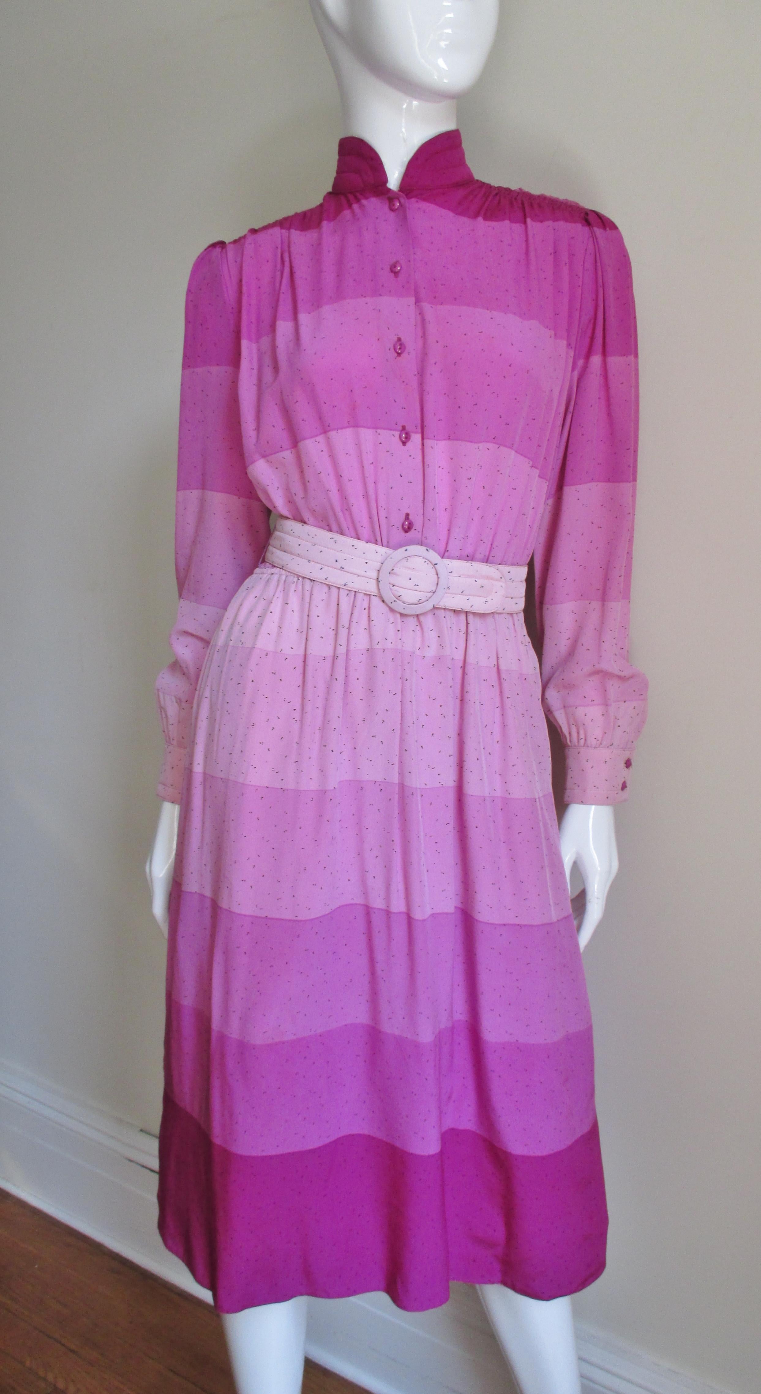 A beautiful silk dress in wide horizontal gradated stripes in shades of pink from Louis Feraud.   It is a long sleeve shirtwaist style dress with a stand up collar, matching buttons on the front and cuffs plus a matching belt.  Easy and comfortable