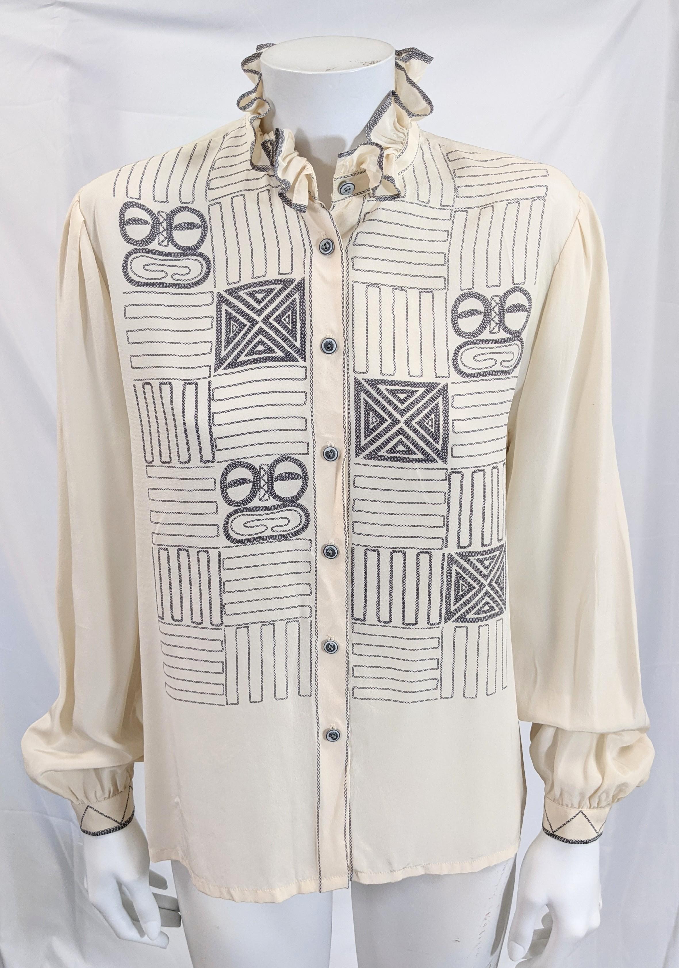 Unusual Louis Feraud silk crepe blouse with faux top stitching printed in black on cream, forming patterns which have slightly Eskimo overtones. Ruffle accents with topstitching on neck of blouse.   1980's France. 
23