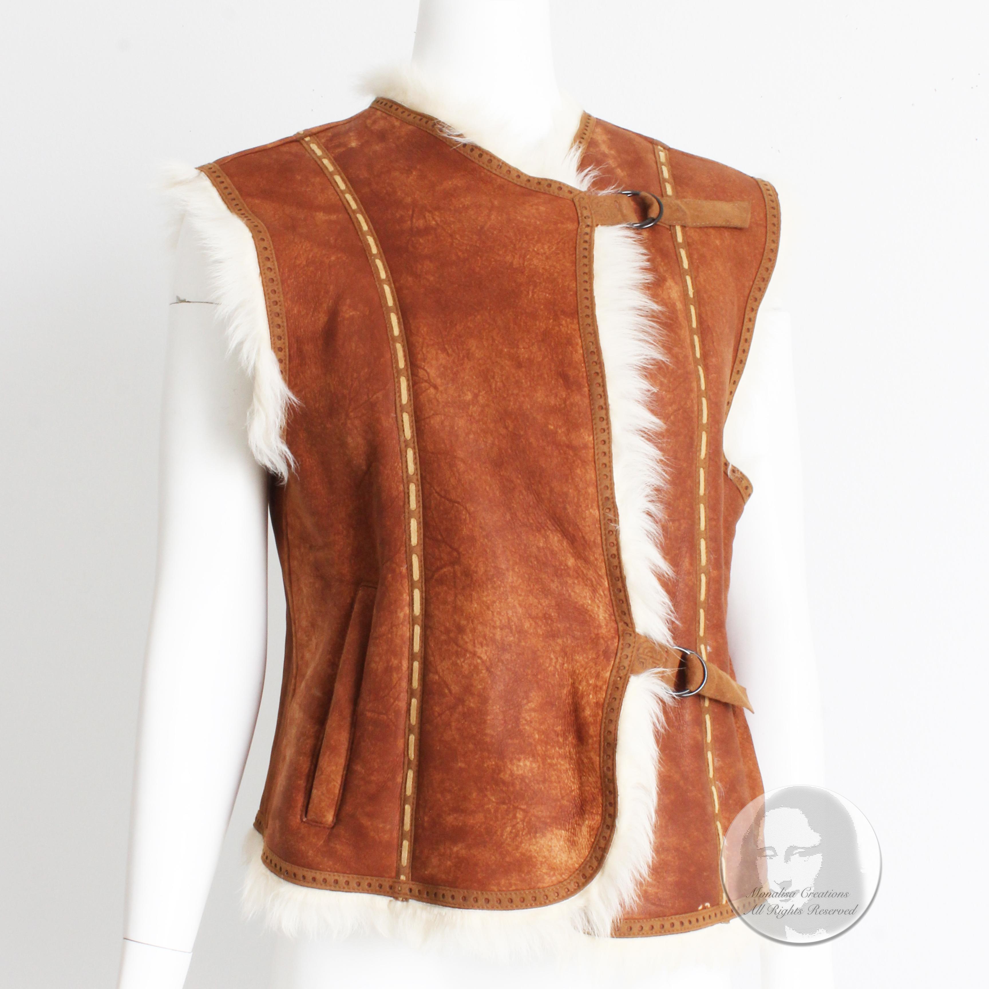 Preowned, vintage Louis Feraud shearling vest with contrast whipstitching, likely made in Canada in the early 2000s. 

Made from rust-hued brown shearling, it fastens with suede straps and rings and has slash pockets at each side. The white