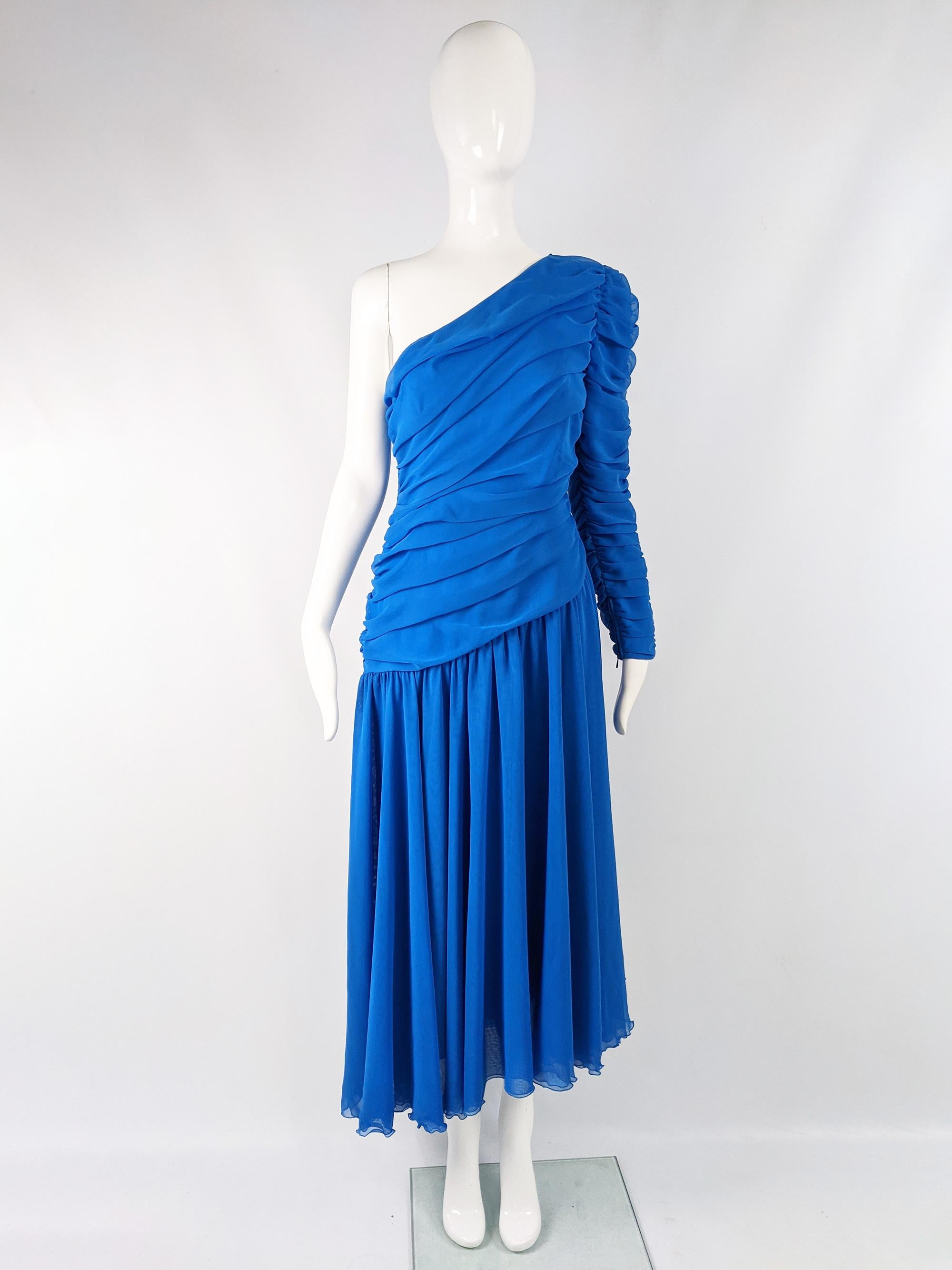 A beautiful vintage evening dress from the 80s by Parisian fashion designer, Louis Feraud. In a blue ruched chiffon with one sleeve, an asymmetrical cut and a gathered skirt.

Size: Marked vintage 42 but fits like a modern womens UK 10/ US 6/ EU 38.