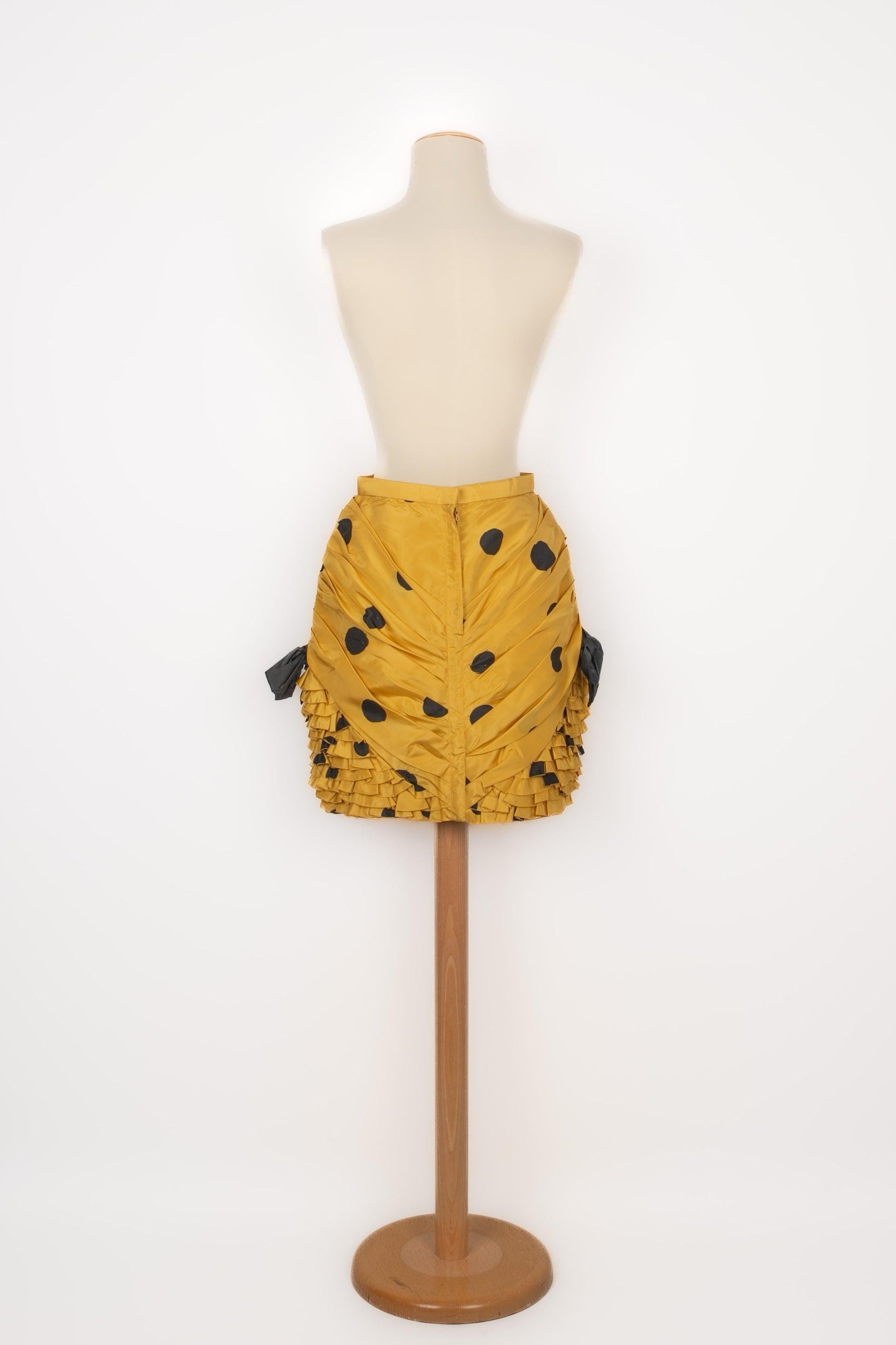 Louis Feraud - Yellow taffeta skirt with black polka dots, decorated with flounces and black bows. No size indicated, it fits a 34FR/36FR.

Additional information:
Condition: Very good condition
Dimensions: Waist: 32 cm - Hips: 47 cm - Length: 47