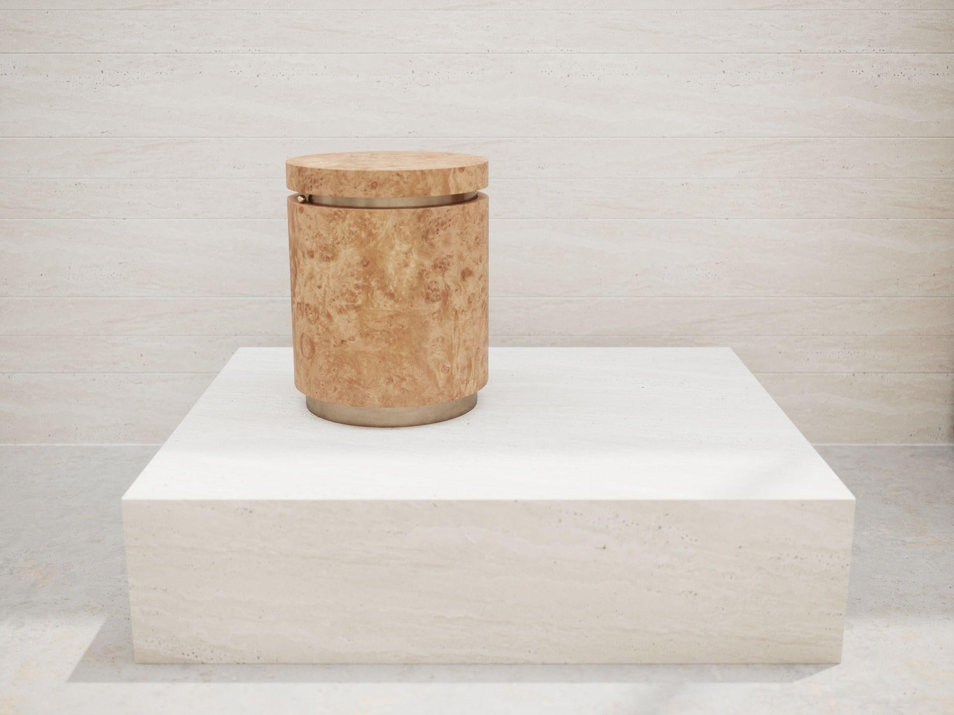 Side table with cylinder shape in Natural Chestnut Burl veneer  and Cloudy Bronze  metal finish for spacer, plinth and interior. Round glass shelf.
Impeccable combination of the form ant texture.
