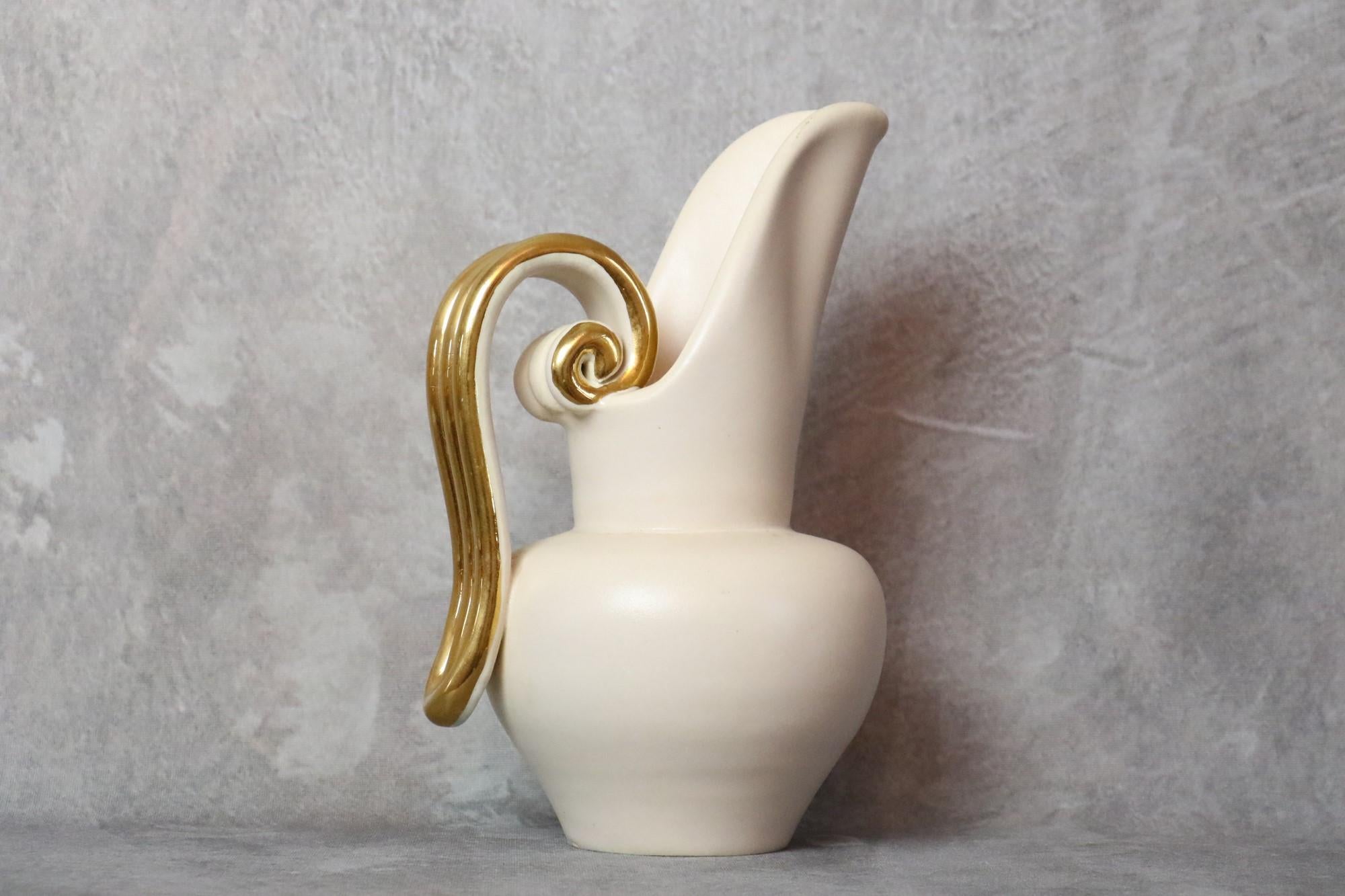 Louis Giraud Pichet en céramique blanc et or du milieu du siècle, Vallauris, 1960

Il s'agit d'une très belle pièce, élégante et délicate. L'émail est très doux, il y a un beau contraste entre le fond blanc laiteux et la poignée dorée.

Sur la