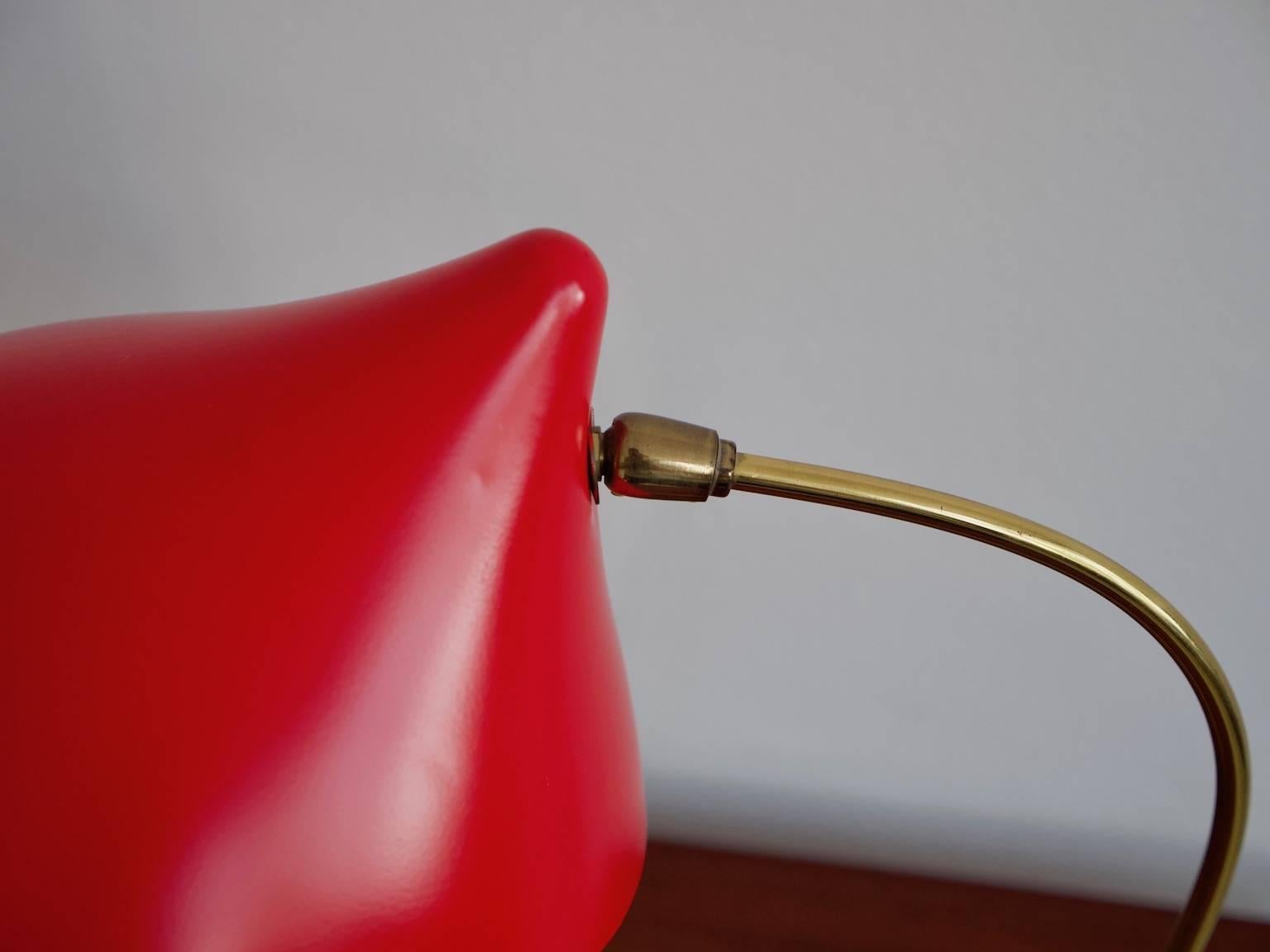 Red table lamp with crowfoot by Louis Kalff for Philips from the 1950s. Three-beam metal foot with cream white shrink lacquer finish, brass tube rod and adjustable, recently re-lacquered red shade with cream white on the inside. Slight traces of