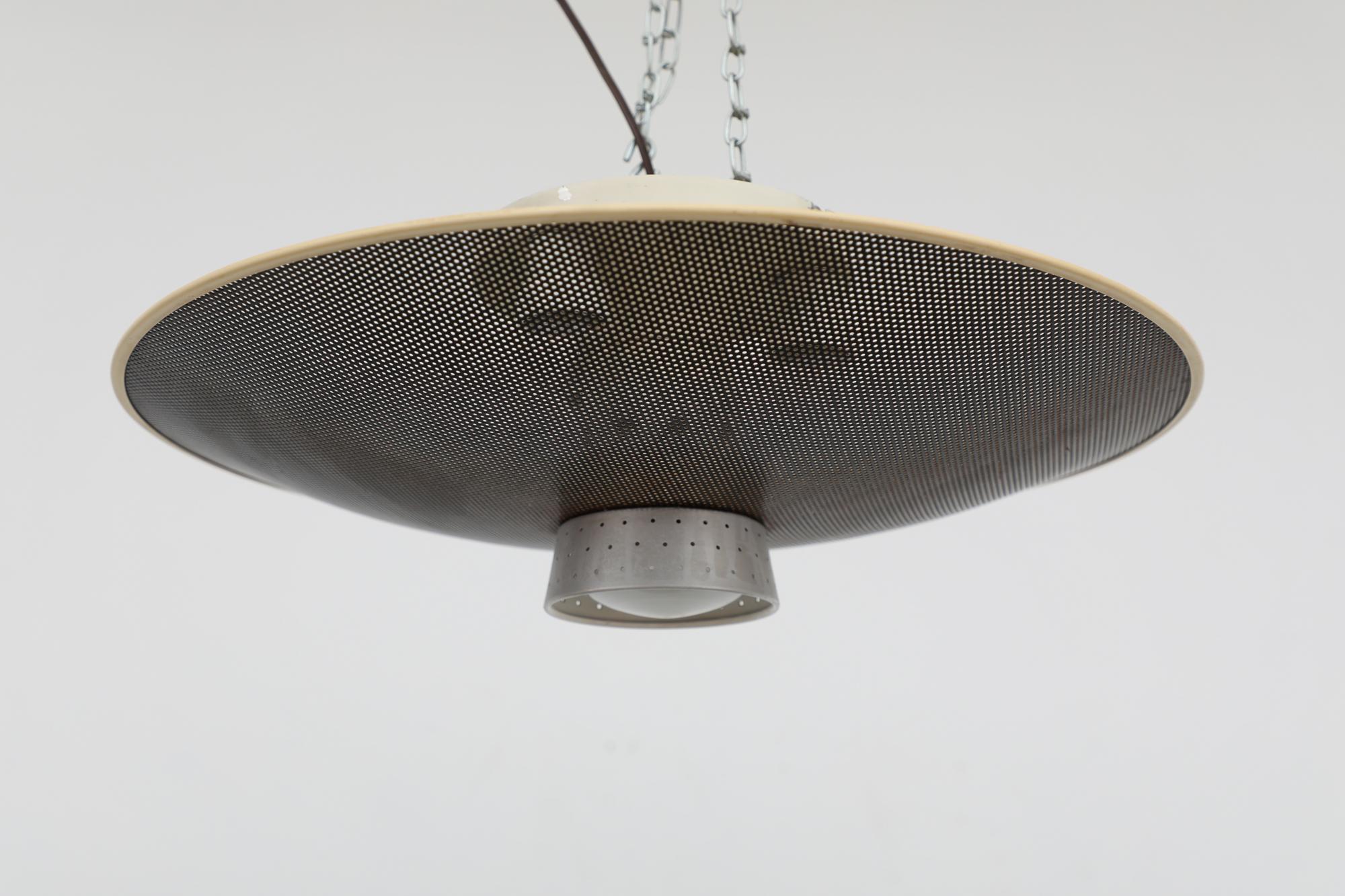 1960s flush mount ceiling lamp designed by Louis Kalff for Philips. The lamp has a perforated dome shade, three upper bulbs and a single downward socket housed in a semi-perforated aluminum shade. In original condition with visible wear, including