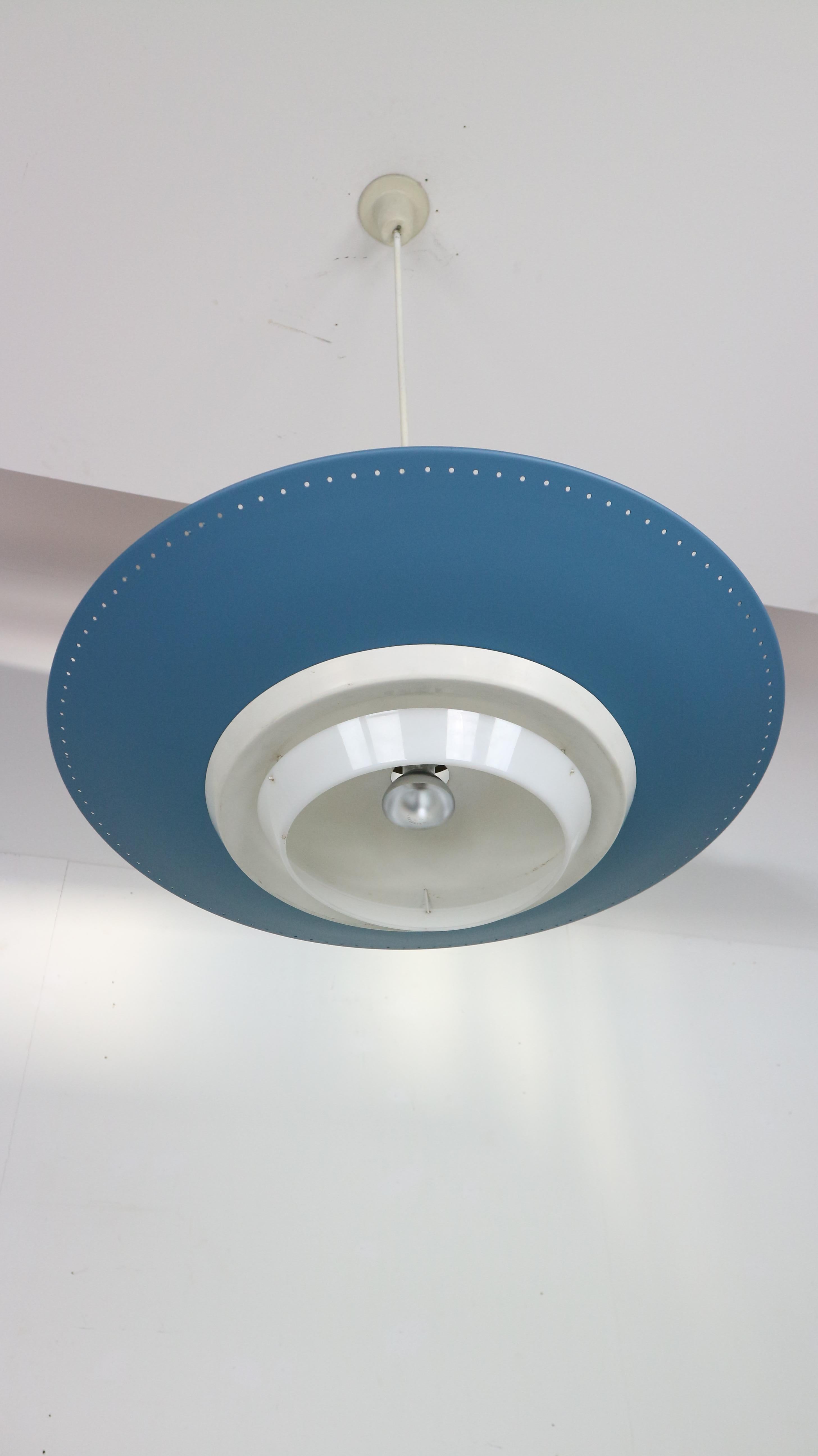 Original 1950s industrial enamelled metal rondelle ceiling pendant lamp designed by Louis Kalff for Philips in 1950s.
Original Dutch industrial design.
Blue enamelled spun aluminium shade with perforated edge and bone white accents. Triple light