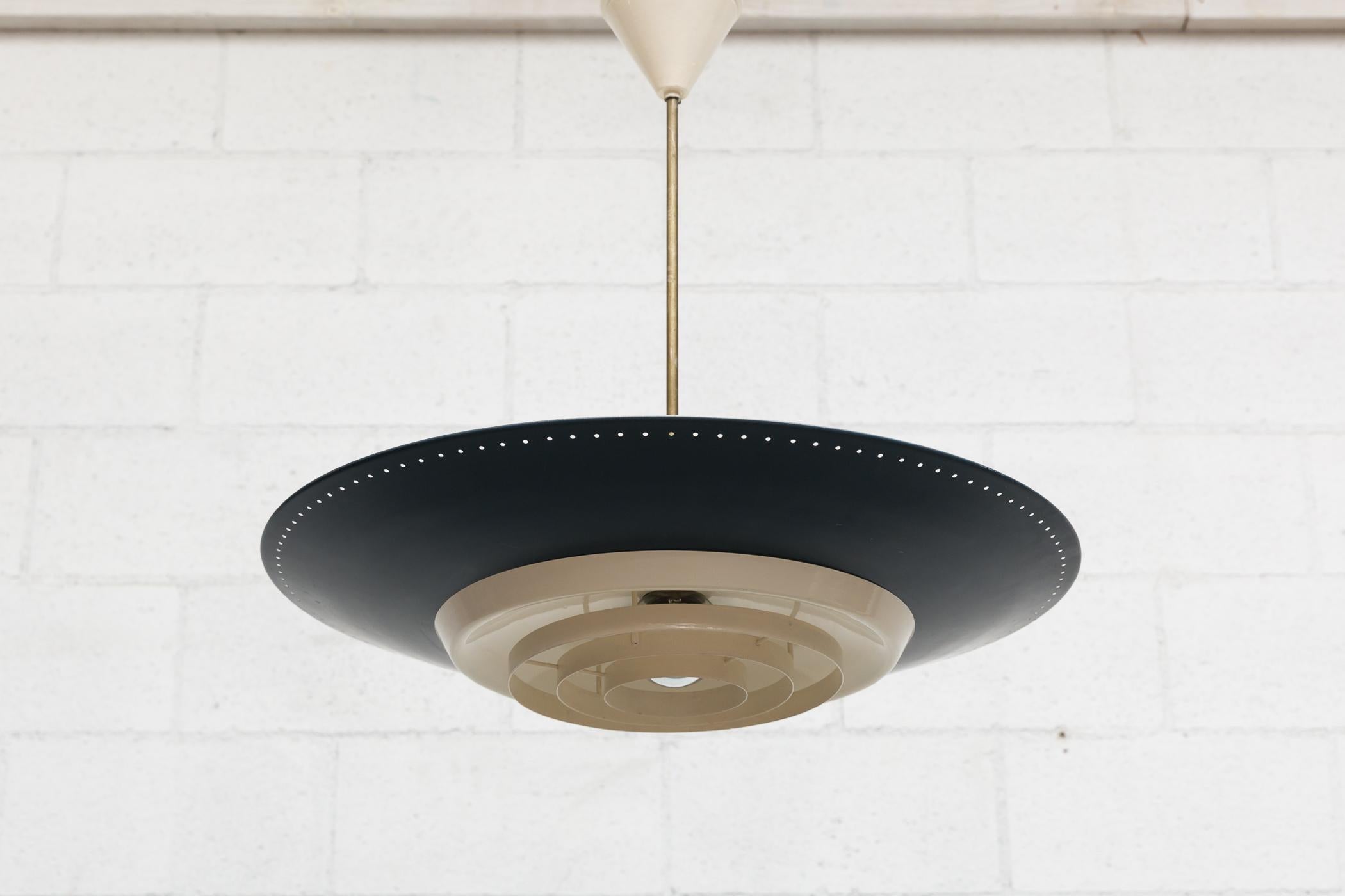 Original 1950s industrial enameled metal rondelle ceiling pendant. Deep blue enameled spun aluminium shade with perforated edge and bone white accents. Triple light sockets for uplighting and a single spot for below with triple enameled metal ring