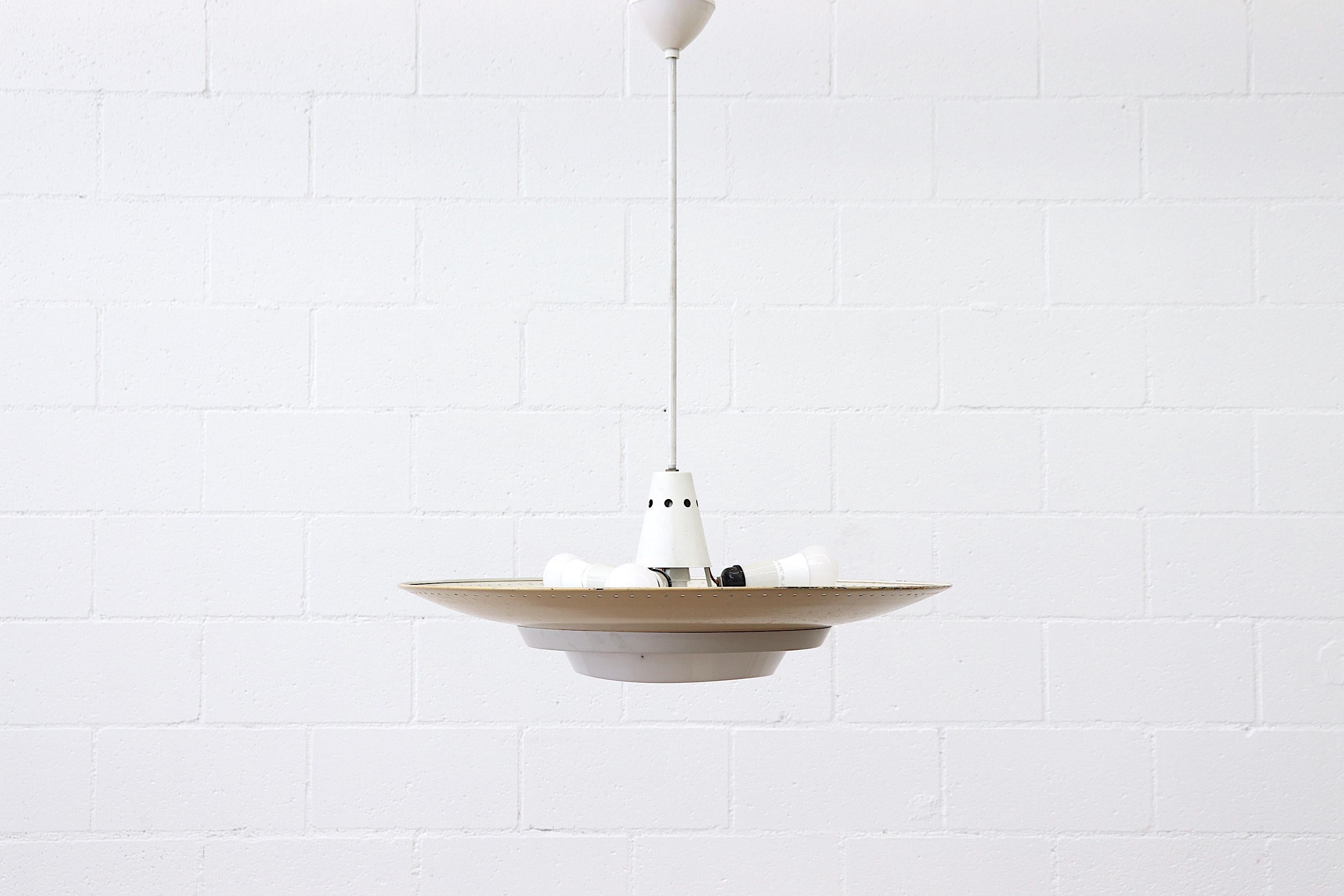 Original 1950s industrial enameled metal Rondelle ceiling pendant. Yellow enameled spun aluminum shade with perforated edge, and bone white accents. Triple light sockets for uplighting and a single spot for below. White acrylic diffuser ring that