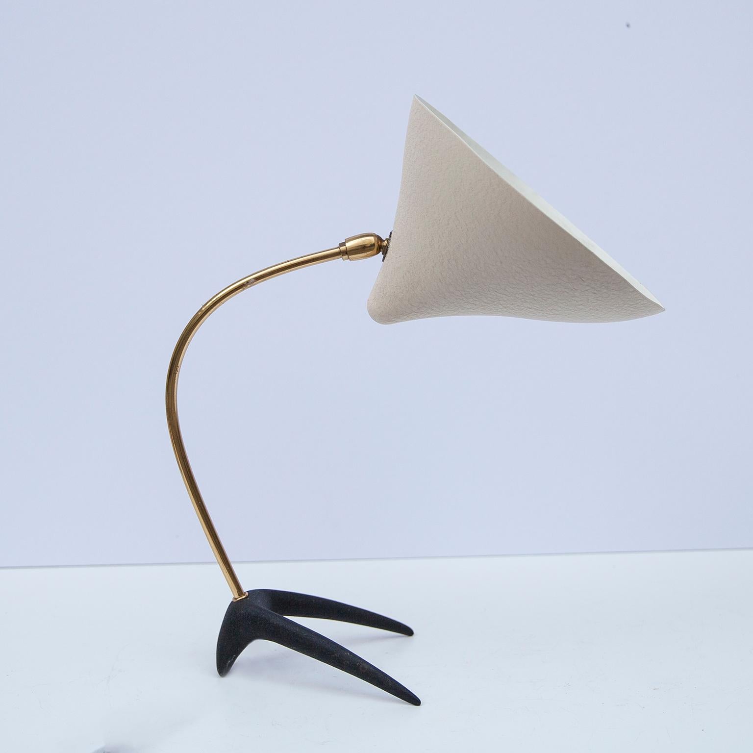 Vintage table lamp with a cast iron foot and a curved brass base, designed by Louis Kalff in the 1950s for Philips Netherland. The conical shade was made of aluminium, white lacquered. The table lamp has an on/off switch and an original E 27