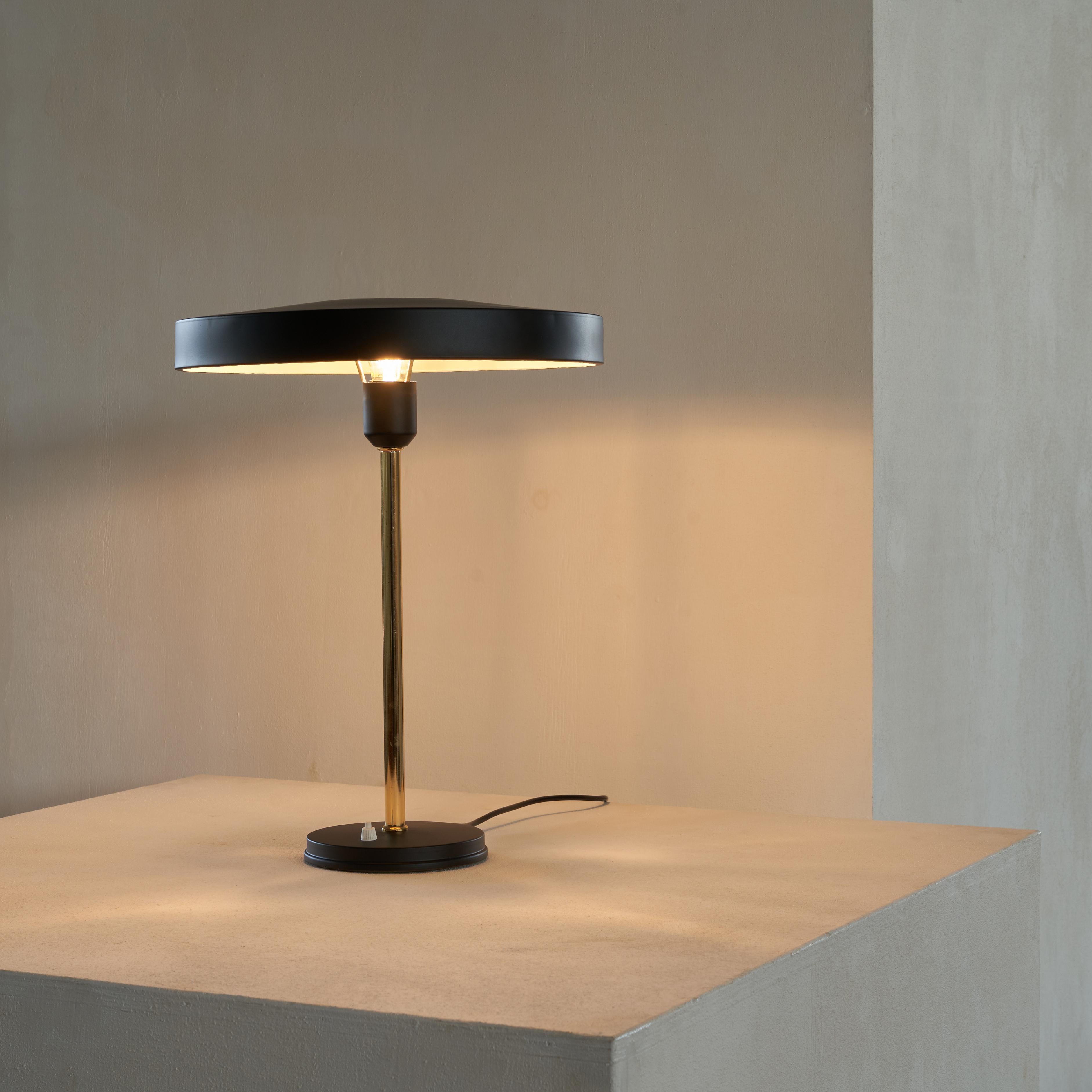 Louis Kalff 'Timor' table lamp. The Netherlands, 1960s.

Surprisingly large and imposing desk lamp by Louis Kalff. A simple and elegant design, with a metal base and shade and a stem in patinated brass. One of the designs Louis Kalff made for