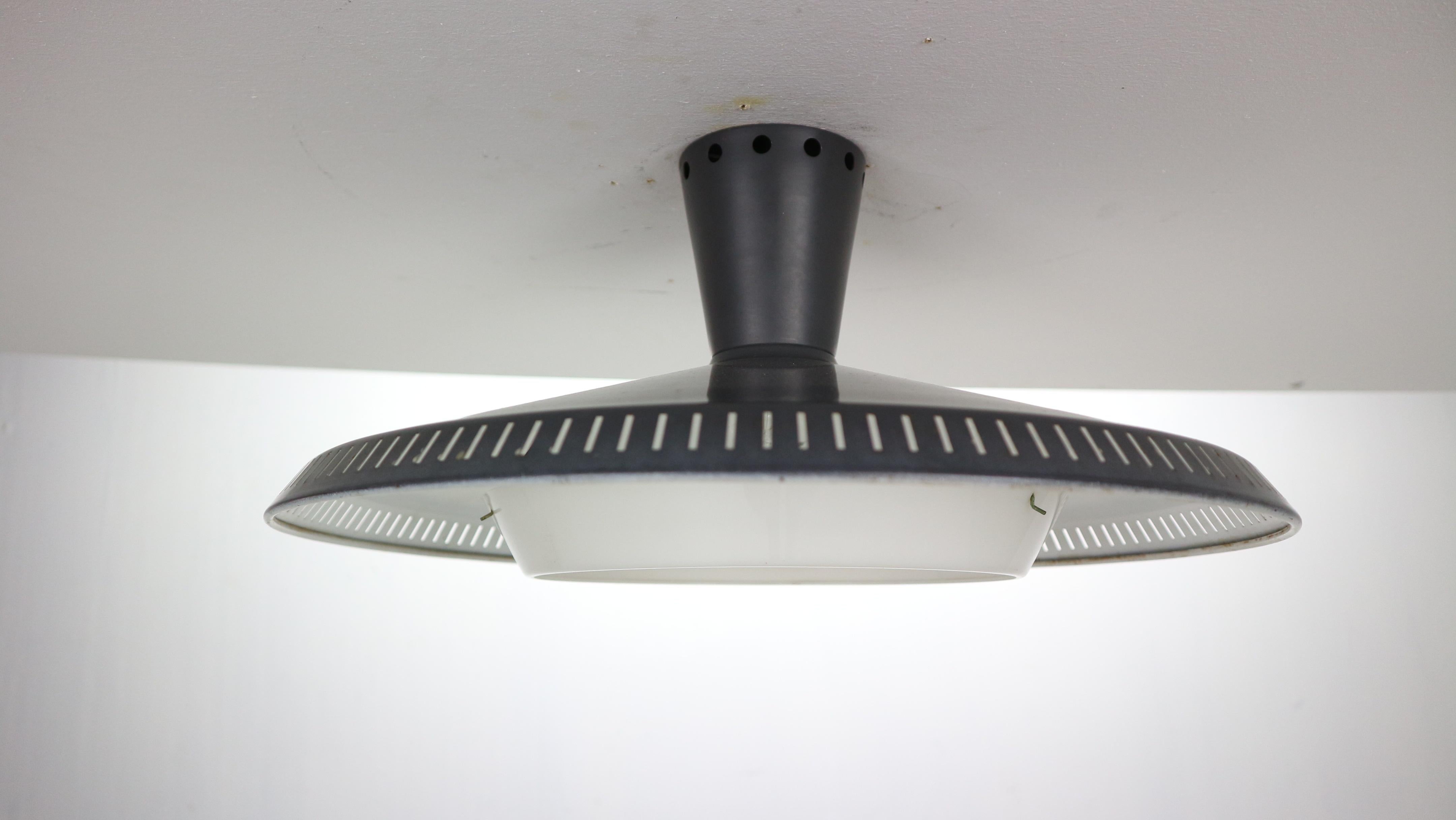Iconic wall or celling lamp designed by Louis Kalff for Philips famous Dutch lightening manufacture in 1959, Netherlands.
Model no. NB92, completely original with an original label.
The shade of the lamp is made of perforated metal and has a dark