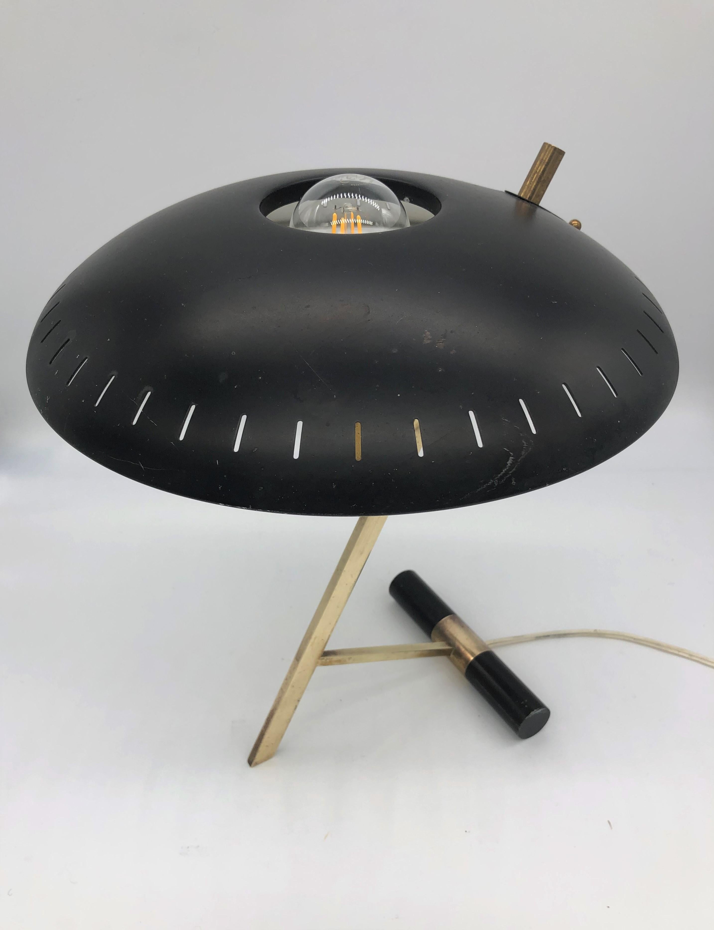 This table lamp designed by Louis Kalff in the 1950s and manufactured by Phillips is an iconic piece of 20th century design. The domed black lacquered metal shade stands on top of a gilt-brass foot. This model, named Z after its shape, is stamped