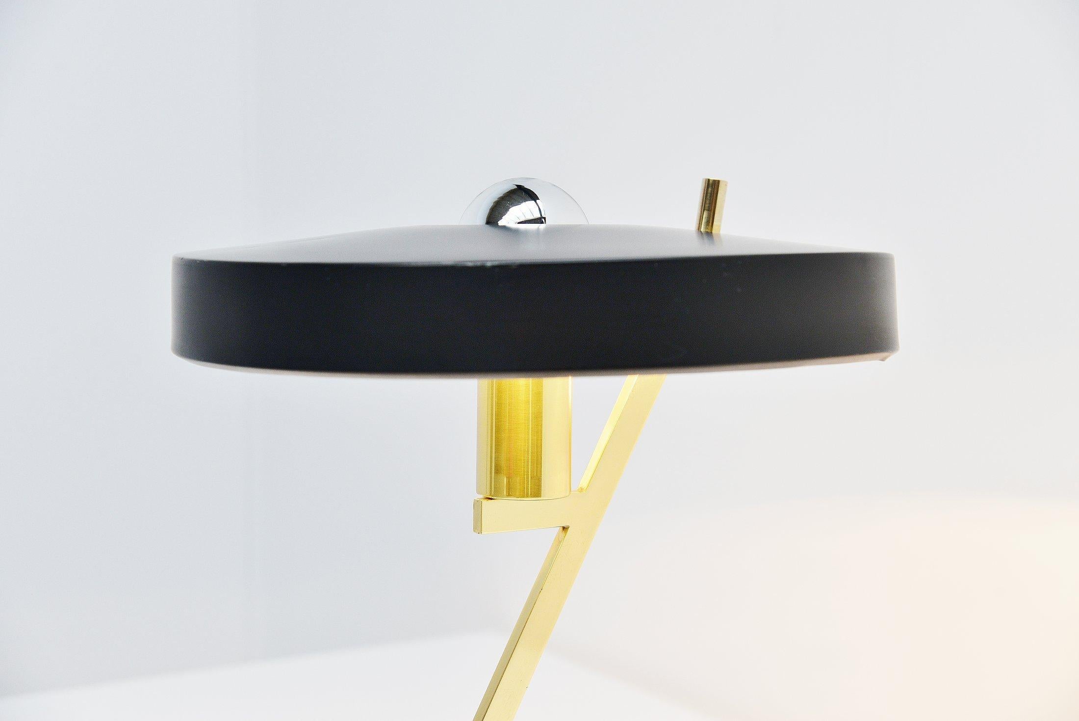 Very nice iconic table/desk lamp designed by Louis Christiaan Kalff and manufactured by Philips, Belgium 1955. This atomic desk lamp has a solid brass base with black lacquered weighted metal end. And it has a black lacquered cylindrical shade. The