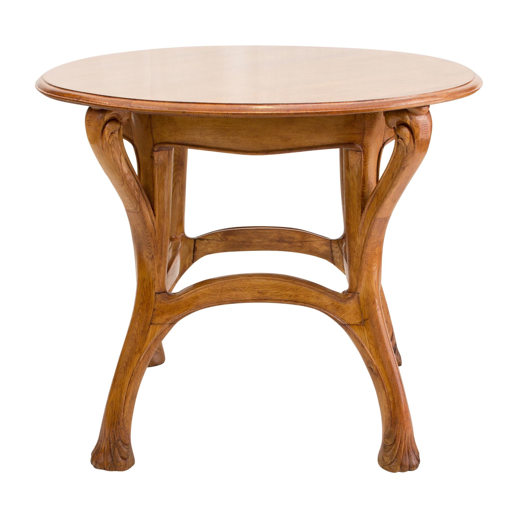 Round table from France, made of solid oak. We attribute the table to Louis Majorelle, or at least to his school in Nancy or to a student, because the double-bearing, outward-curving table legs and the swelling curved bead on the connecting frame,