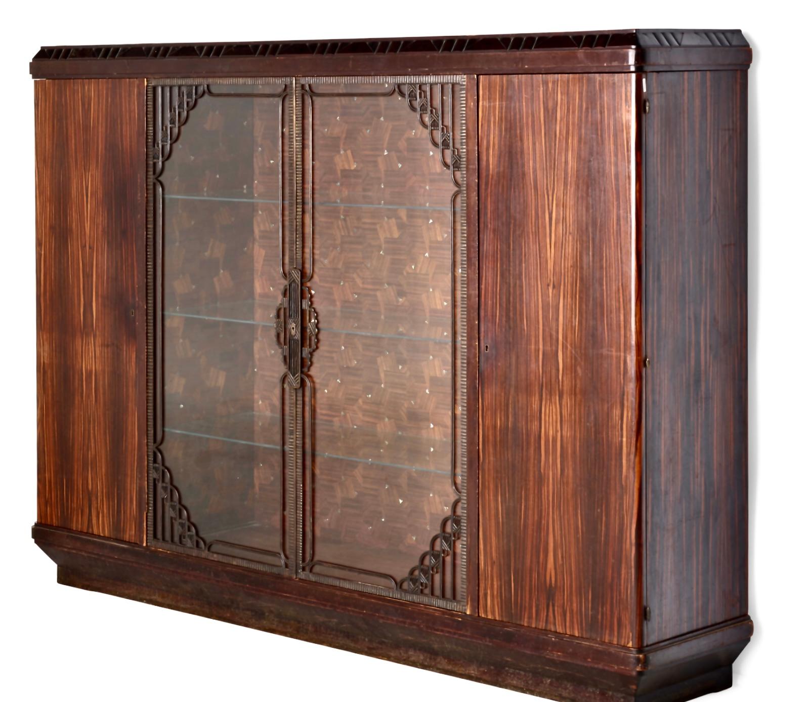 Louis Majorelle, cabinet, France, c. 1919, Macassar ebony, mahogany, mother-of-pearl, glass, patinated bronze. Measures: 66¾ h × 89¼ w × 19½ d in (170 × 227 × 50 cm). Cabinet features four doors concealing three fixed shelves in the center and open