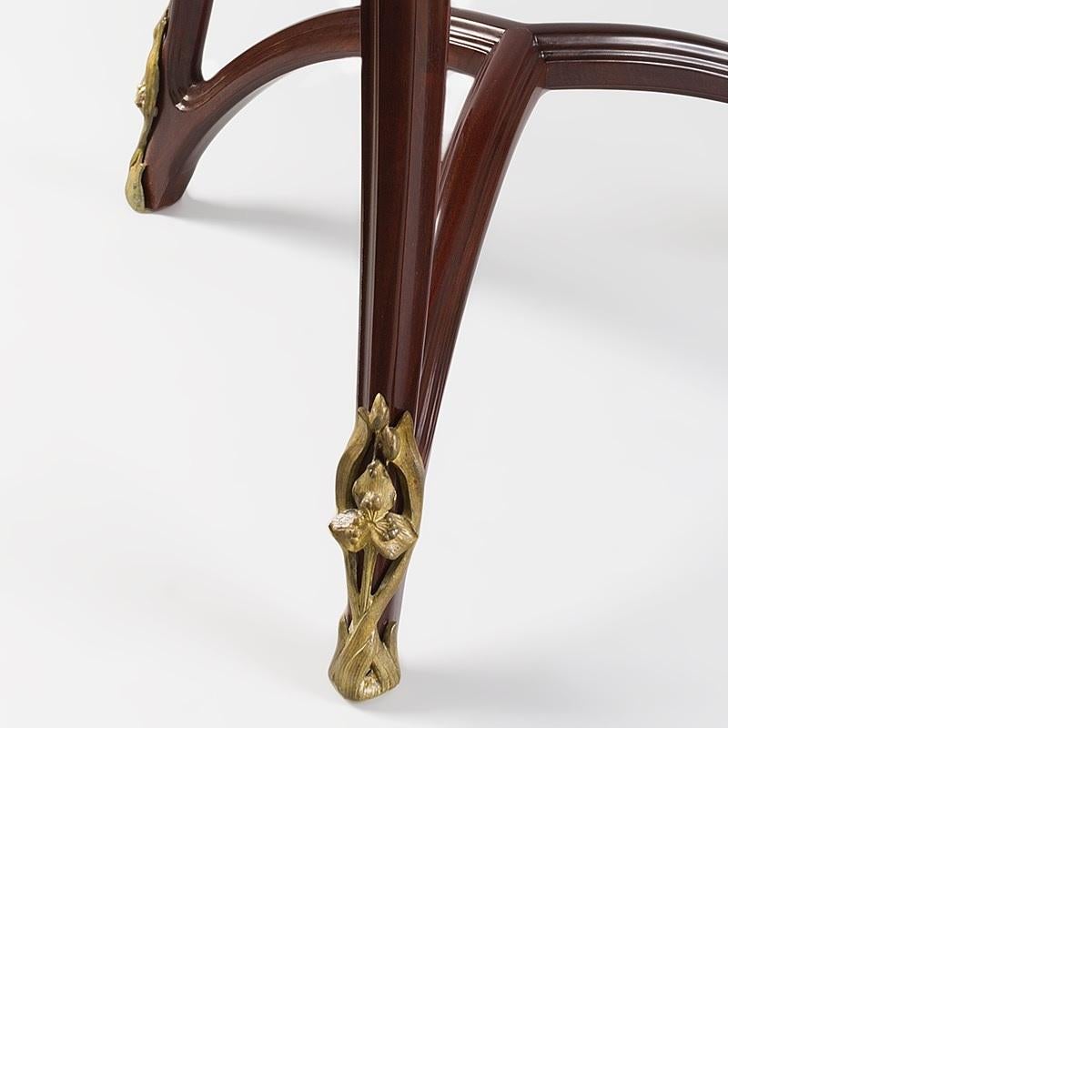 A French Art Nouveau mahogany triangular gueridon with elegant carved decoration and curvilinear design by Louis Majorelle. Each leg ends in a gilt bronze sabot, circa 1900.

A similar table is pictured in: Louis Majorelle: Master of Art Nouveau