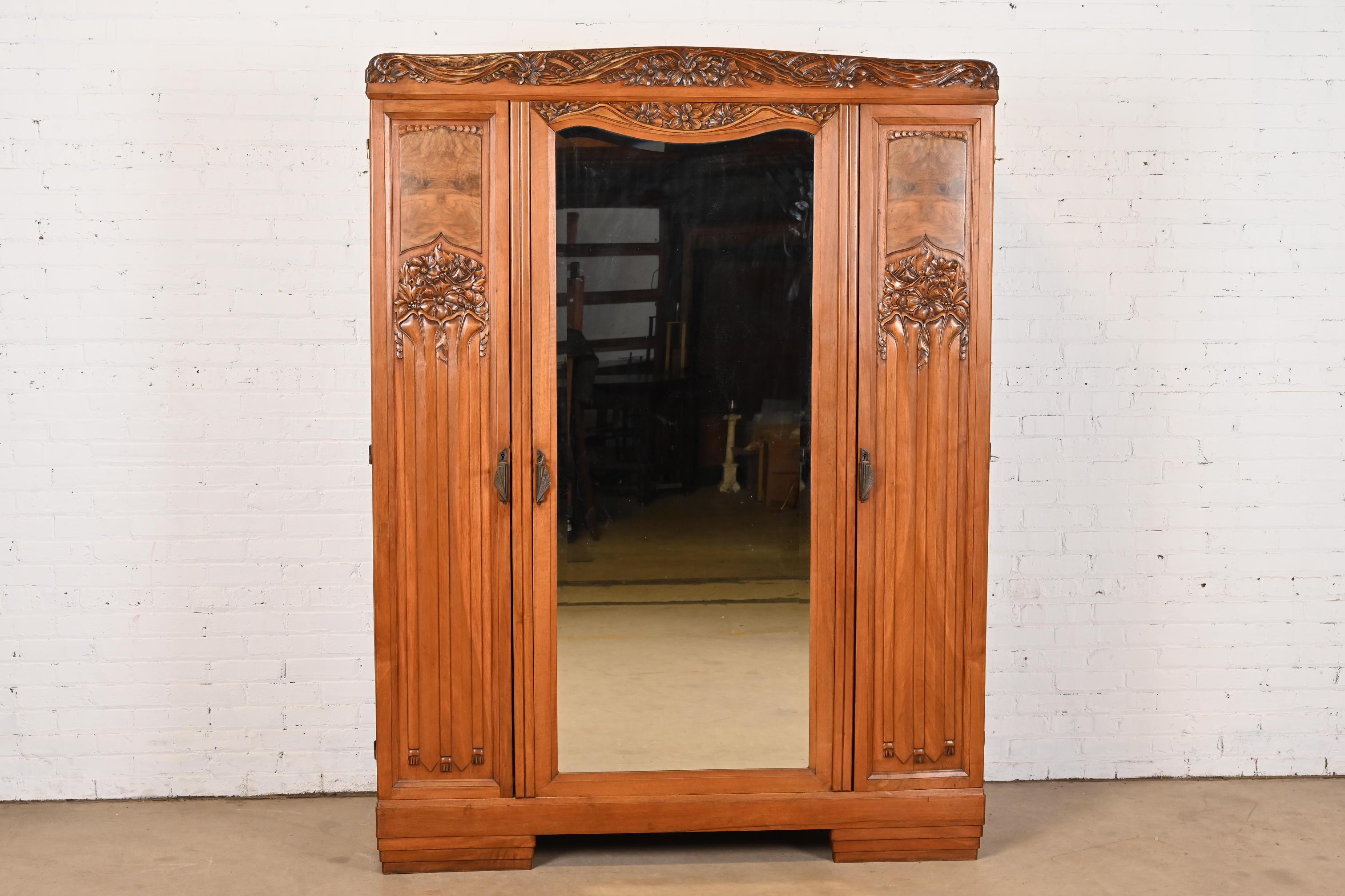A stunning antique French Art Nouveau or Art Deco period knockdown armoire dresser, linen press, or wardrobe

In the manner of Louis Majorelle

France, Circa 1920s

Carved walnut, with burled walnut panels, original brass hardware, and beveled