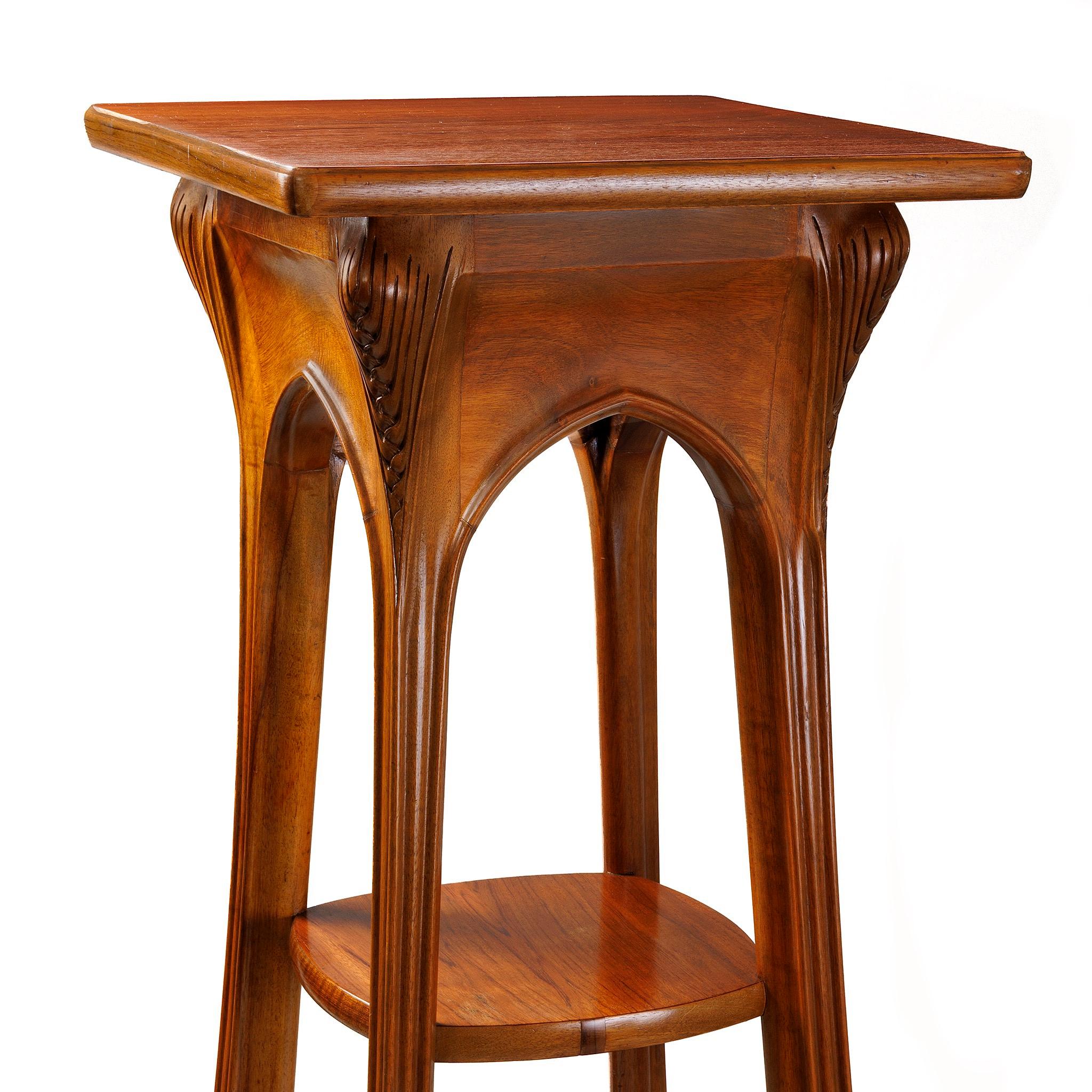 Ce piédestal à trois niveaux en noyer de Louis Majorelle, de style Art nouveau français, est doté d'un plateau rotatif sur le dessus. Des rainures striées ornent la partie supérieure des jambes. Les pieds légèrement incurvés sont également