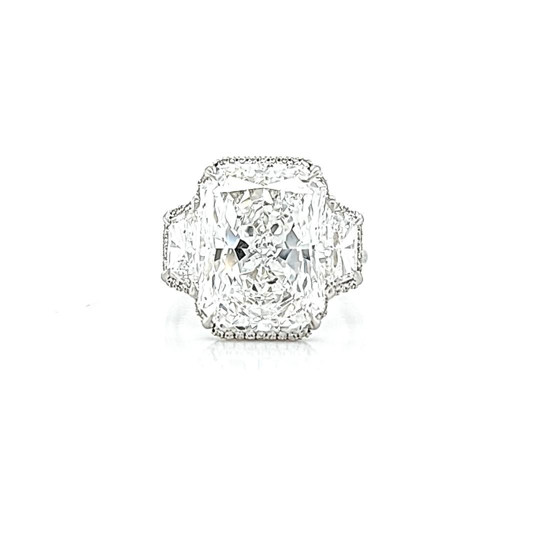 Center stone is an 8.85 carat GIA certified Radiant Cut Diamond with an F color and Si2 Clarity. Great color/clarity combination. Its a great stone at a great price point. Set in a 3 stone ring with 2 elongated brilliant cut  trapezoid diamonds
