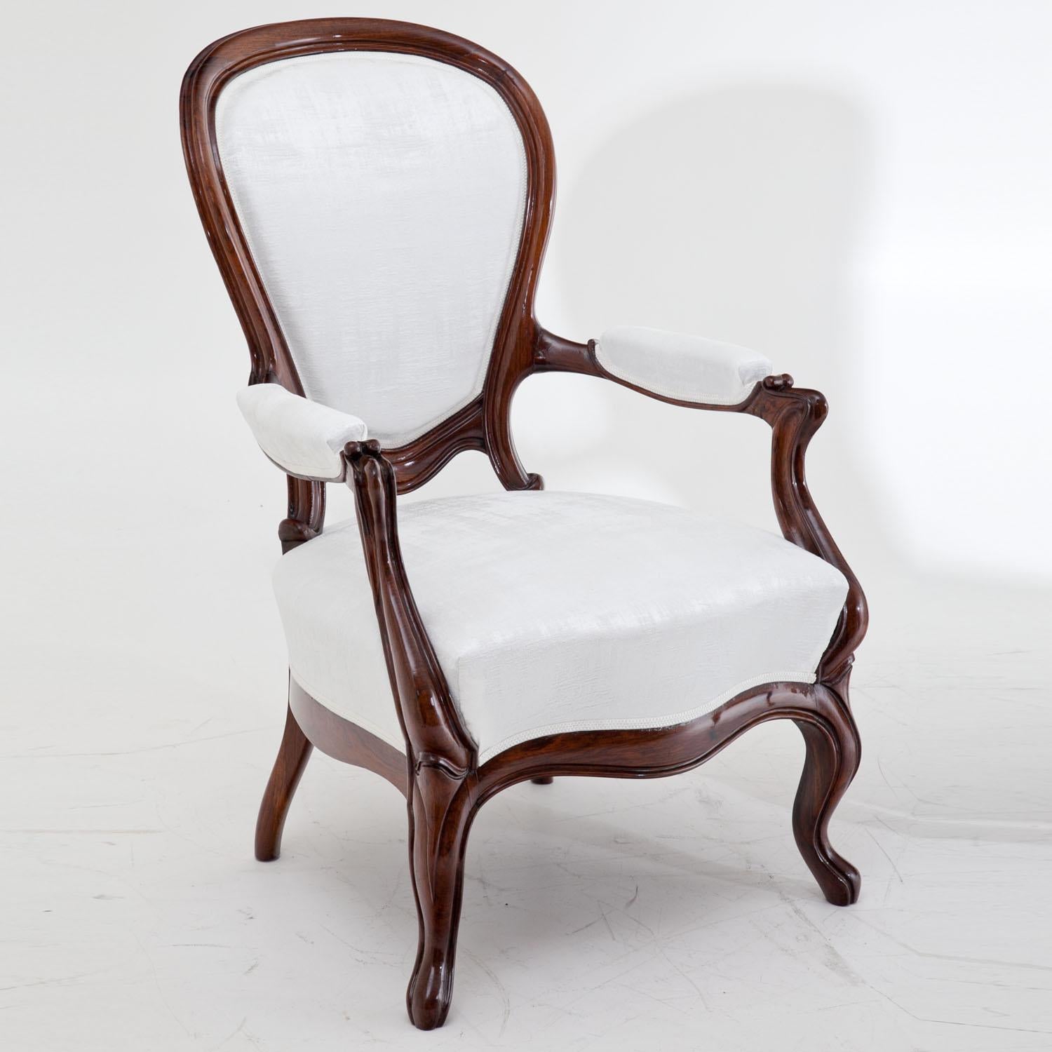 Pair of Louis Philippe armchairs on s-shaped legs with a curved front rail and armrests as well as cushioned seats, backrests and armrests. The chairs were reupholstered with a white slightly structured, high quality fabric.