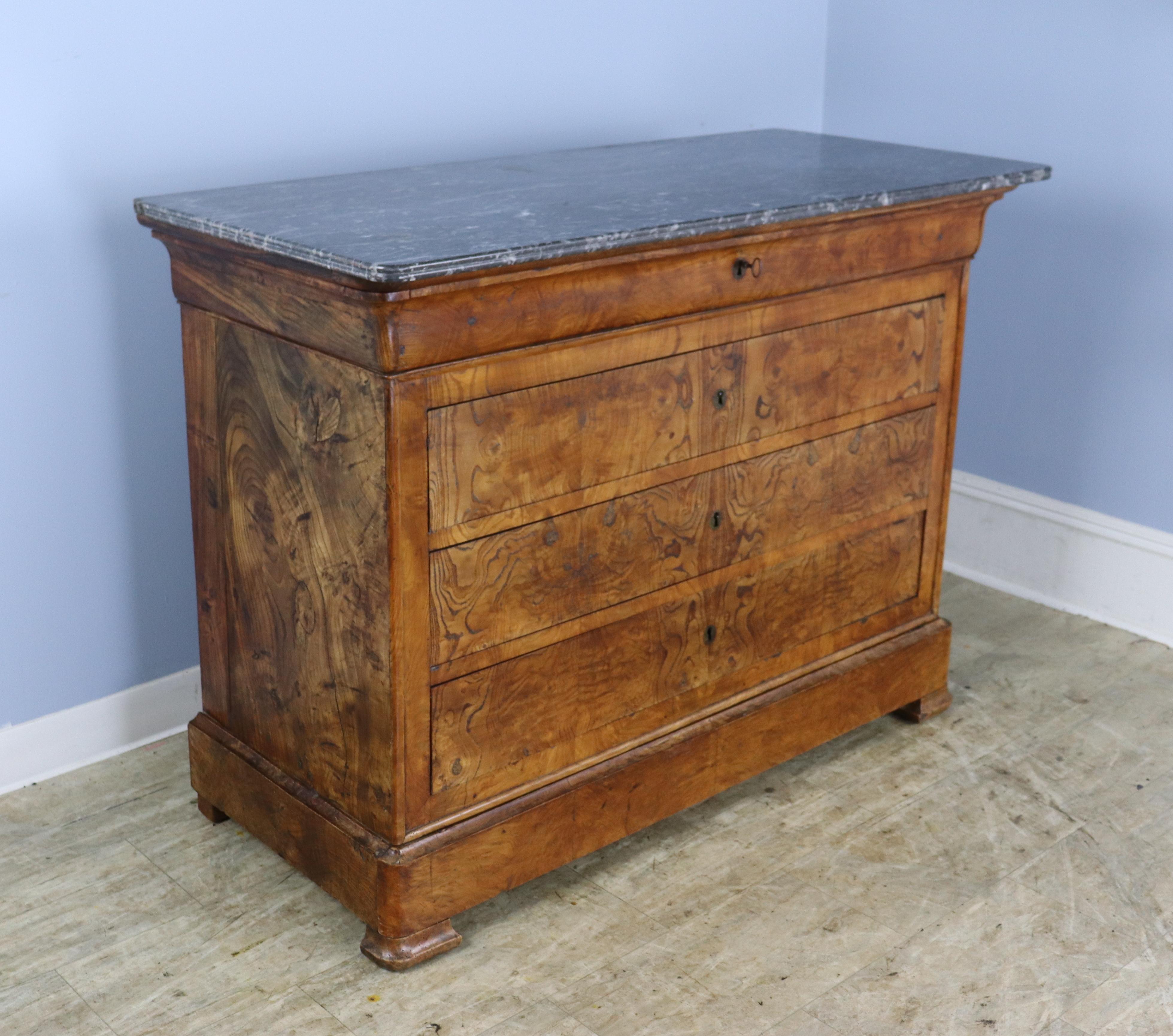 A classic Louis Philippe commode in dramtically grained ash.  Four wide drawers plus an extra hidden drawer in the plinth!  The ash has very good color and patina, and the marble is in nice condition, with a small area of wear toward the back, shown