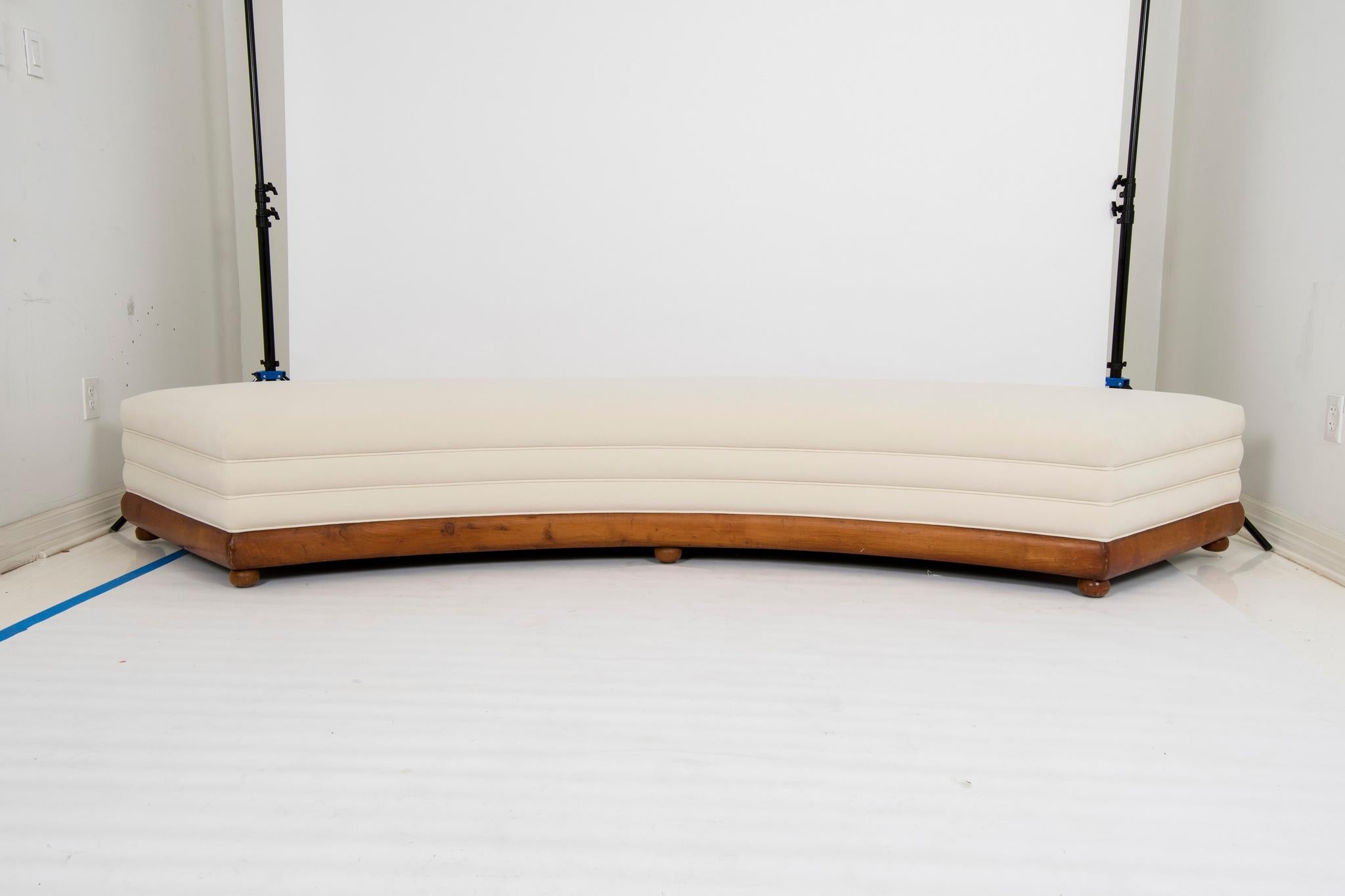 An elongated curved period Louis Philippe mahogany banquette newly upholstered with channeled sides in a creamy ecru low pile velvet.

Overall dimensions: 124