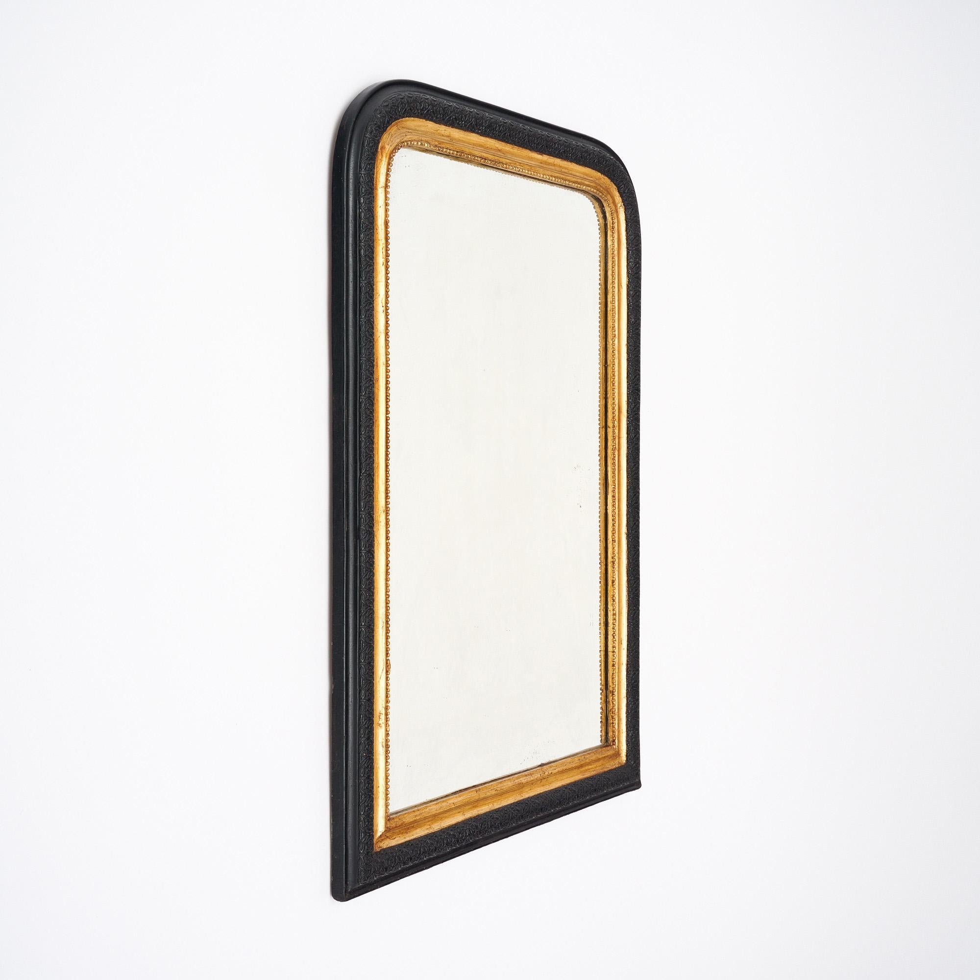 Mirror from the Louis Philippe period in France. This piece has a wooden and stuccoed frame that juxtapose 23 carat gold leaf inside trim and black molding that has been finished with a lustrous French polish. The frame also features the classic