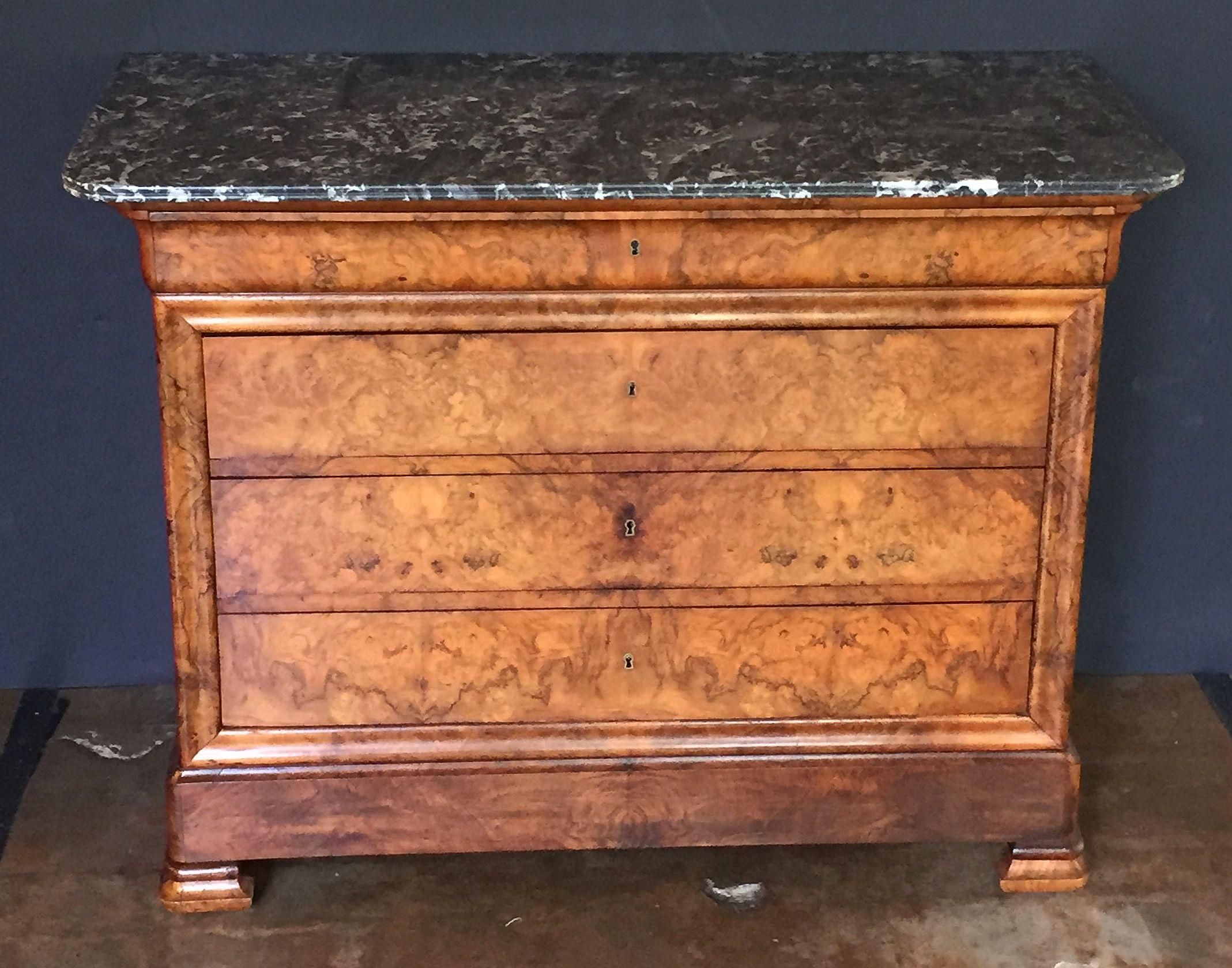 A handsome French Louis Philippe console chest or commode of burr walnut with a figured marble top.
Featuring four fitted long drawers (with key), brass escutcheons and set upon shaped bracket feet.