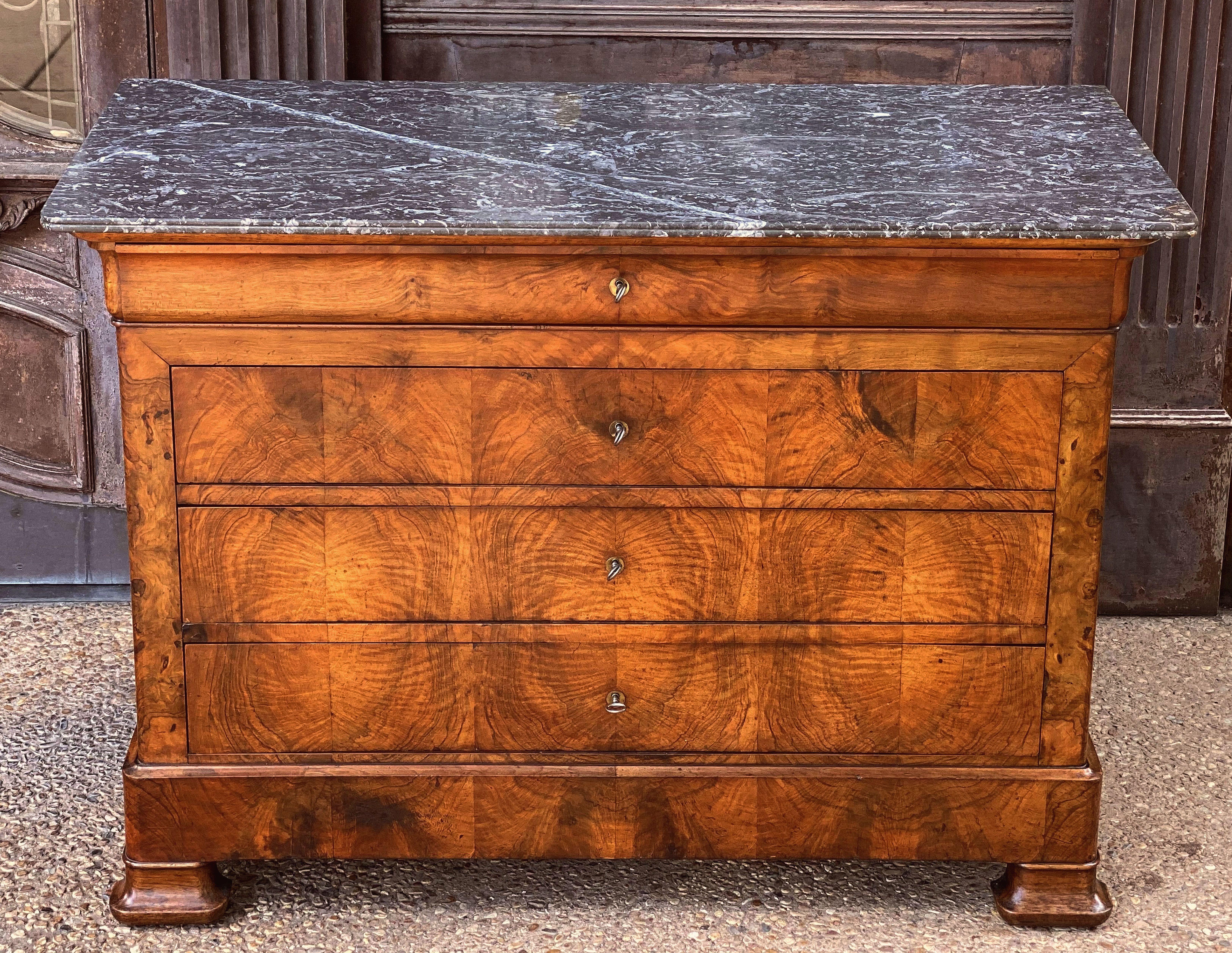 A handsome French Louis Philippe console chest or commode of beautifully patinated burled walnut with a figured marble top.
Featuring four fitted long drawers (with keys), brass escutcheons, and set upon shaped bracket feet.