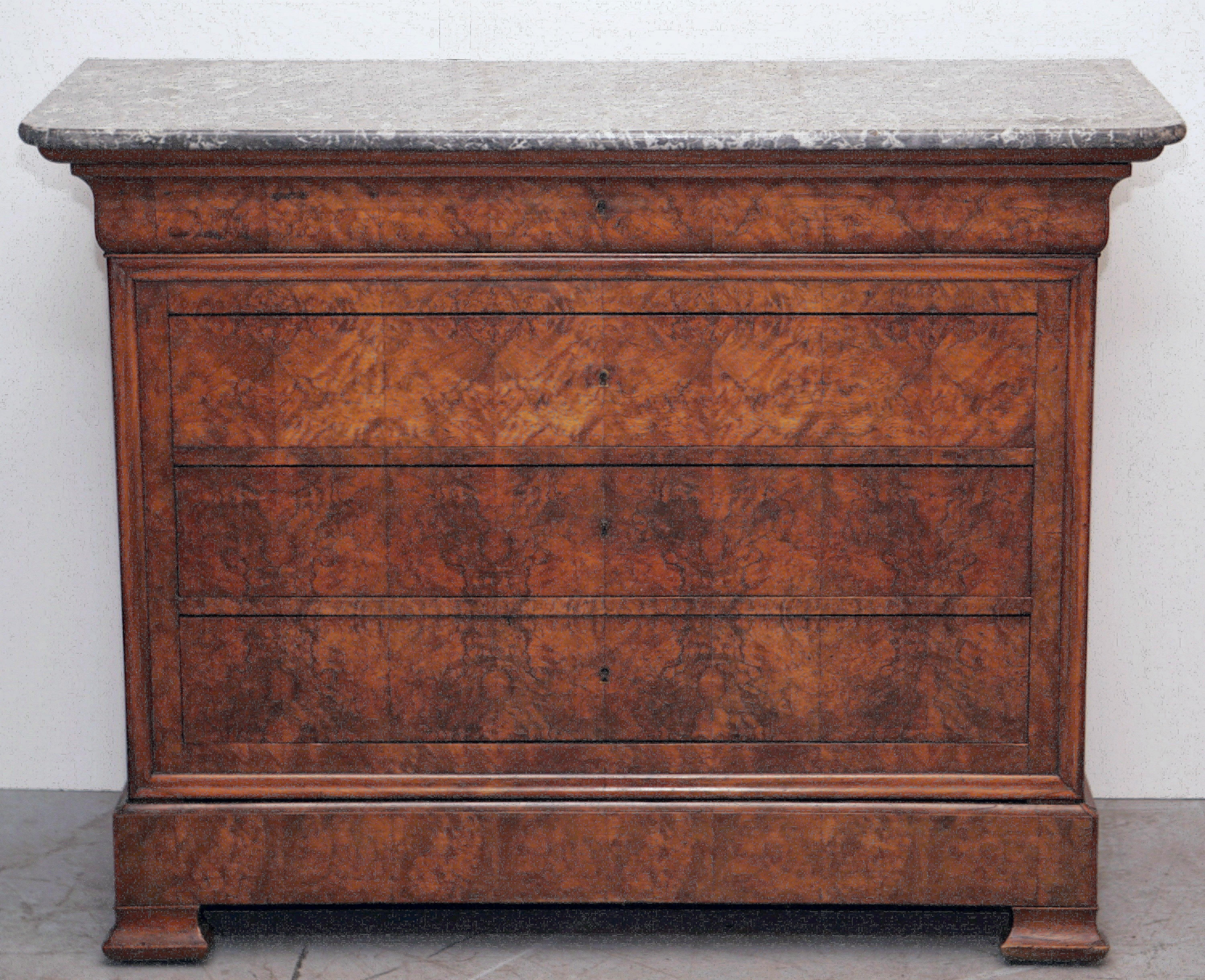A handsome French Louis Philippe console chest or commode of beautifully patinated burled walnut with a figured marble top.
Featuring five fitted long drawers (four with keys), brass escutcheons, and set upon shaped bracket feet.