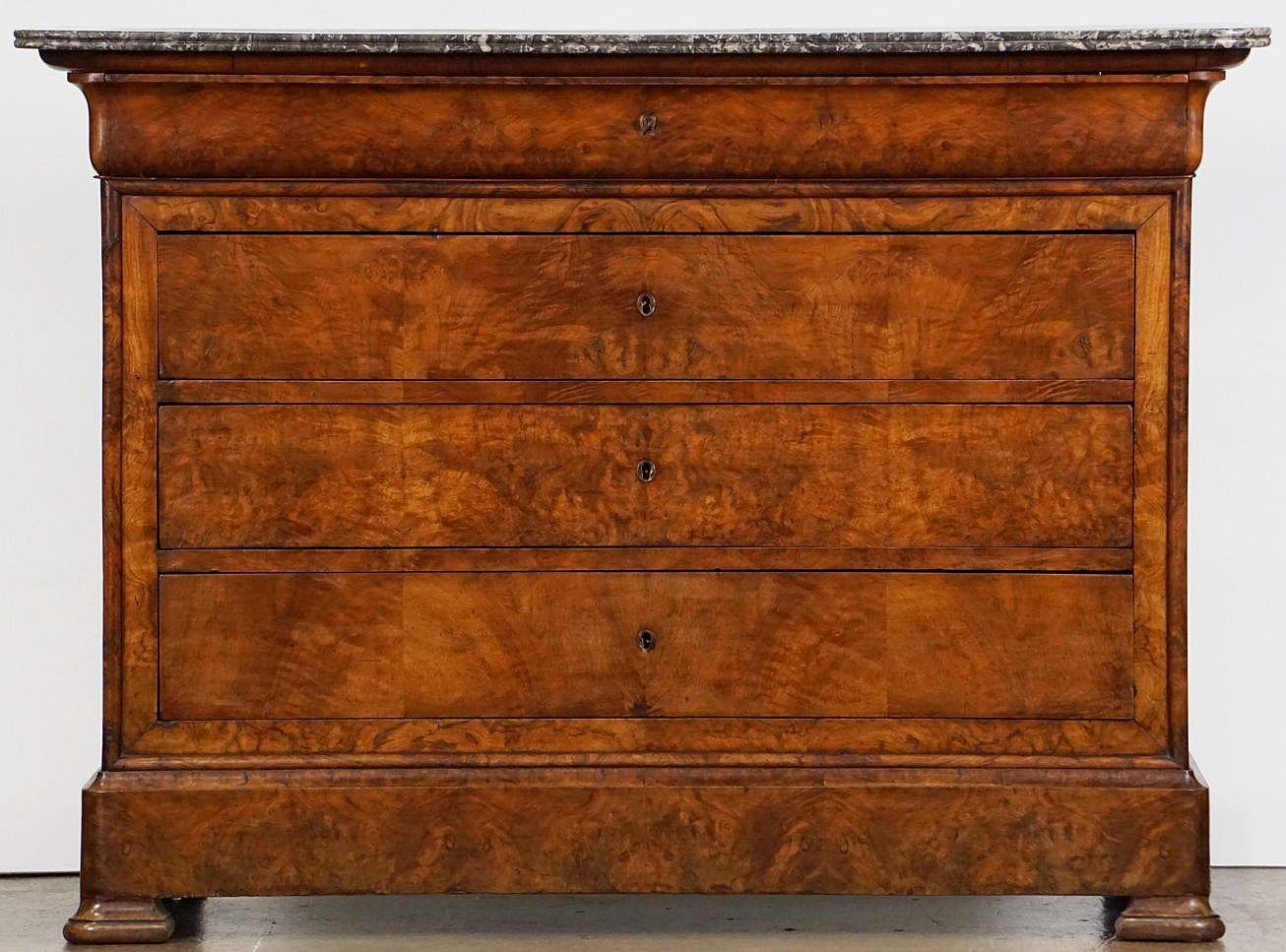 A handsome Louis Philippe console chest or commode from France, of beautifully patinated burled walnut with a figured marble top, featuring four fitted long drawers, brass escutcheons, and set upon shaped feet.