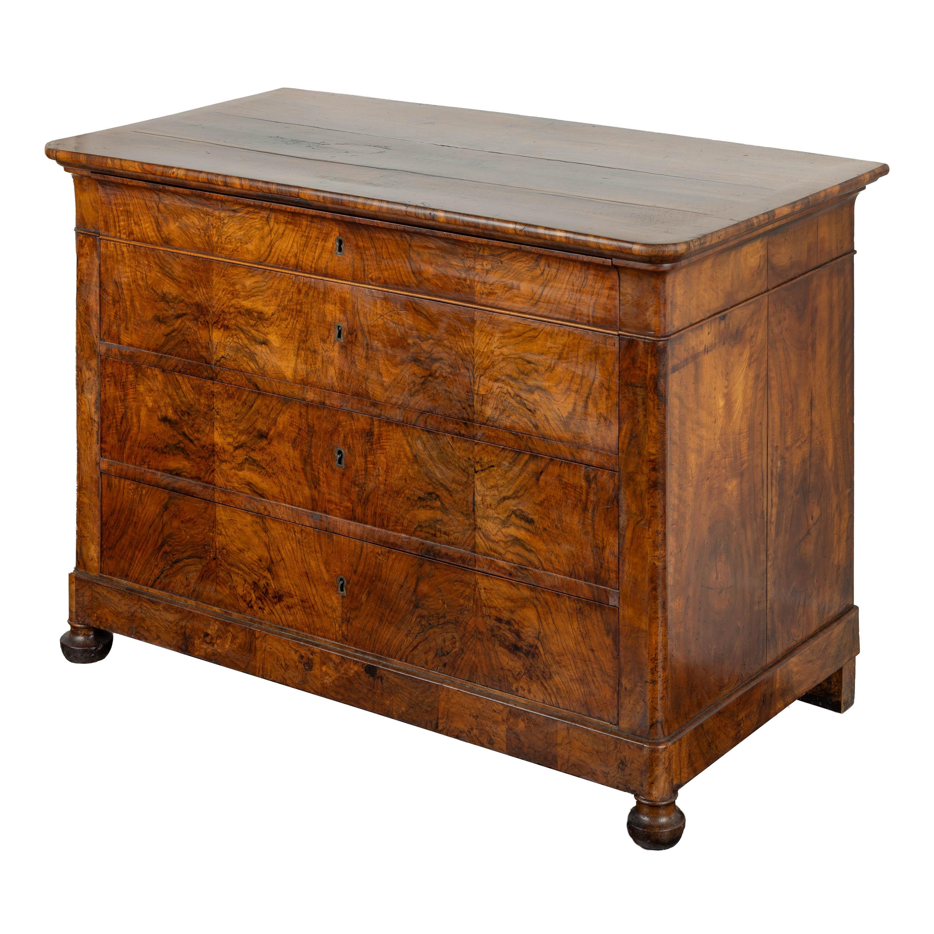 Louis Philippe Chest ca 1850’s. Beautiful details abound in the book matched walnut veneer commode. Pieces of this period rarely have solid planked wood top. 
All drawers glide and are accessed with the original key. Top hidden drawer (no