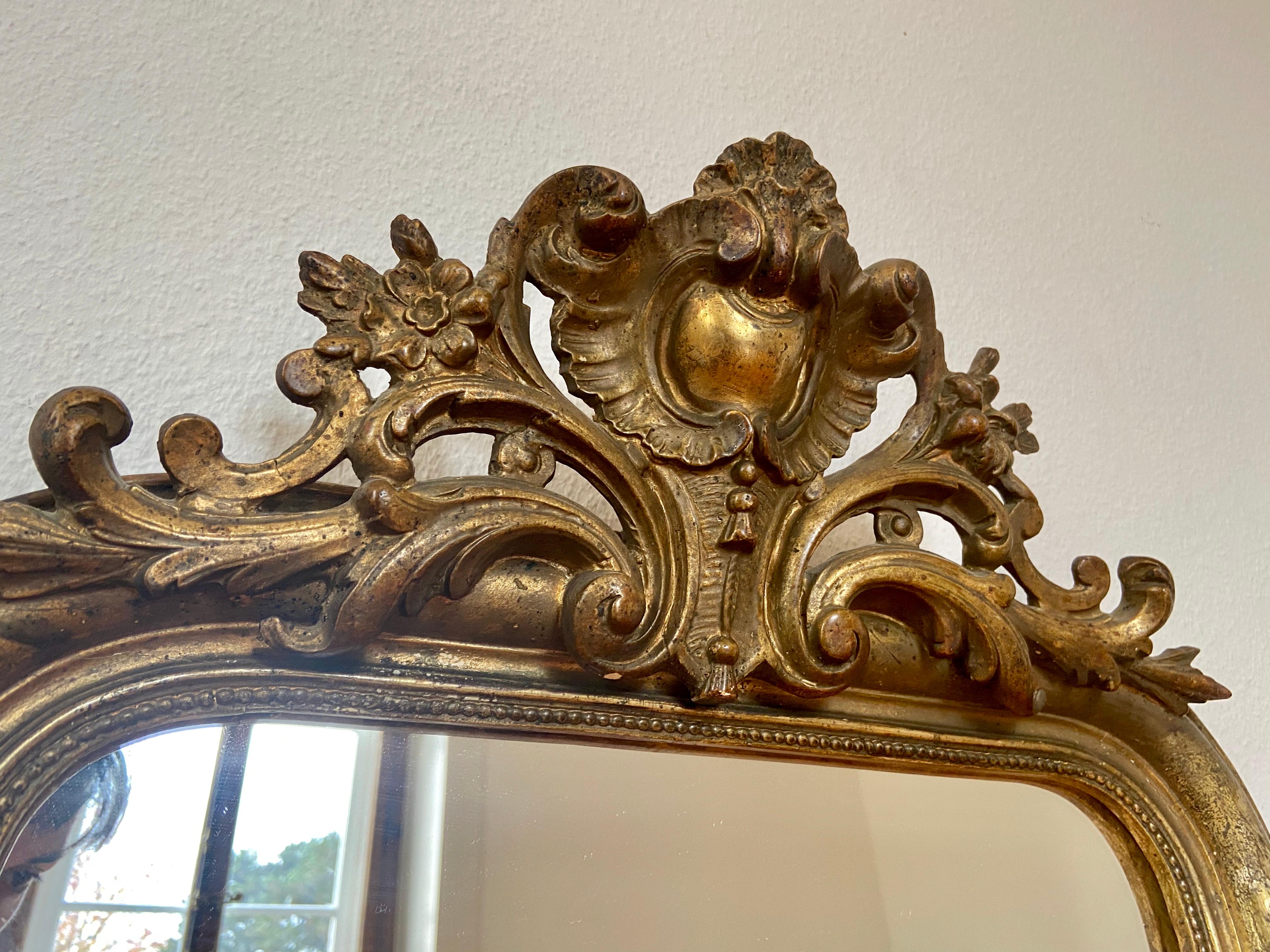 Beautiful authentic gilded Louis Philippe French wall mirror with heart shaped shell crest and rich ornaments. Containing the original mercury glass in ultimate condition.
