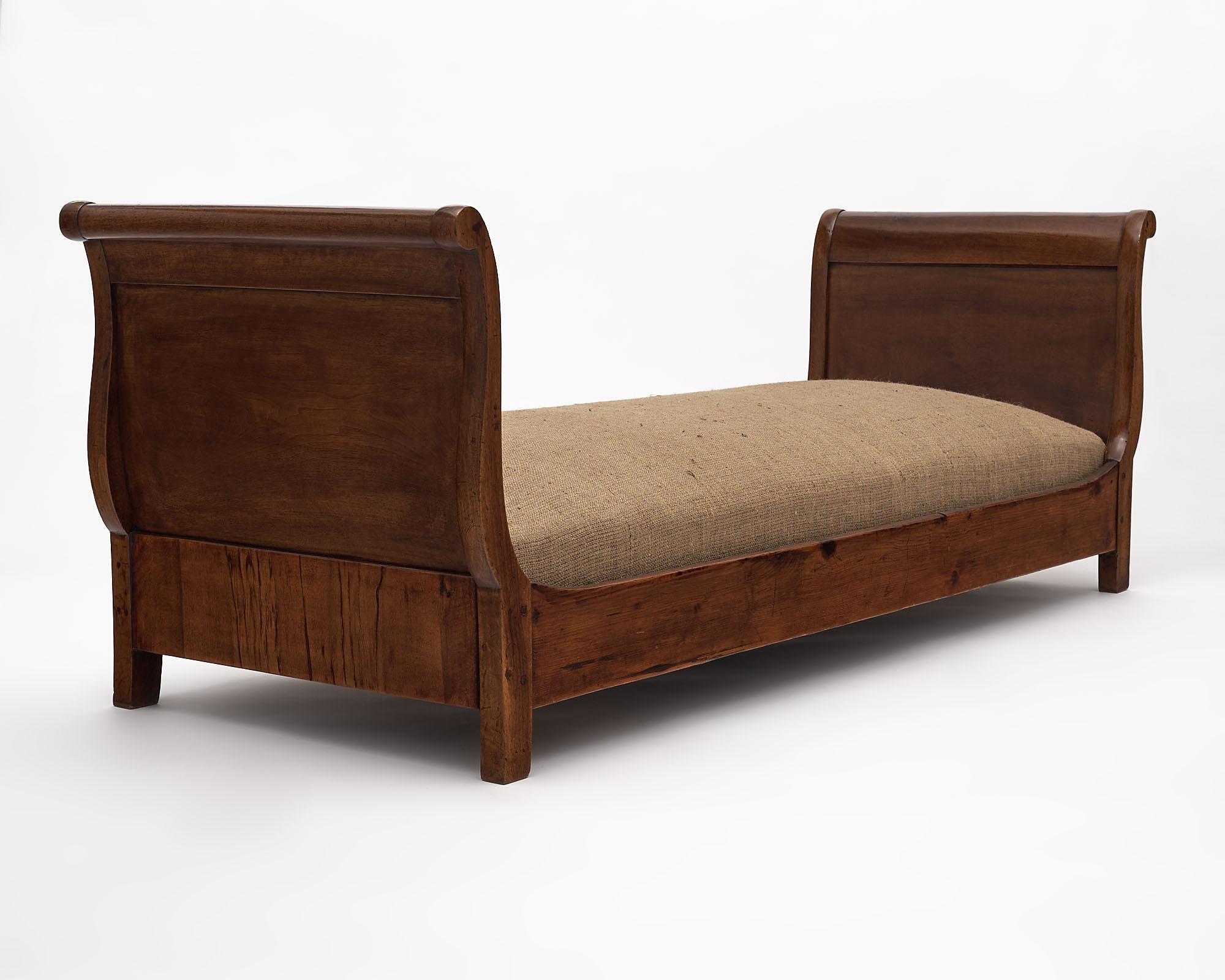 Daybed from France in the Louis Philippe period. This piece has a walnut structure with a beautiful lustrous French polish finish. The seat has been newly upholstered in burlap.