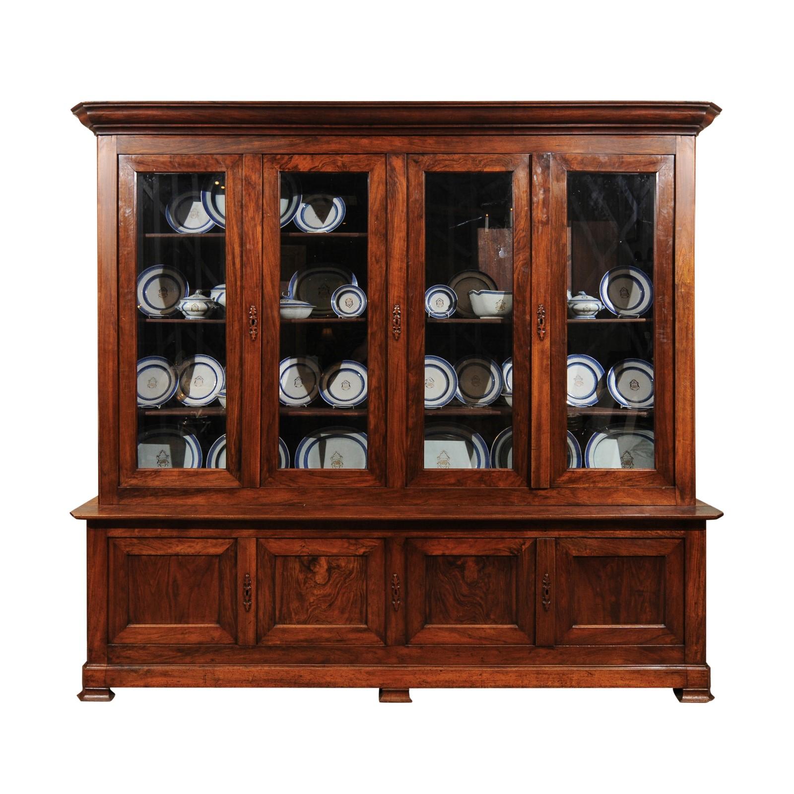 The French Louis Philippe walnut bookcase with 4 glass paneled doors above 4 cabinet doors below. 

 