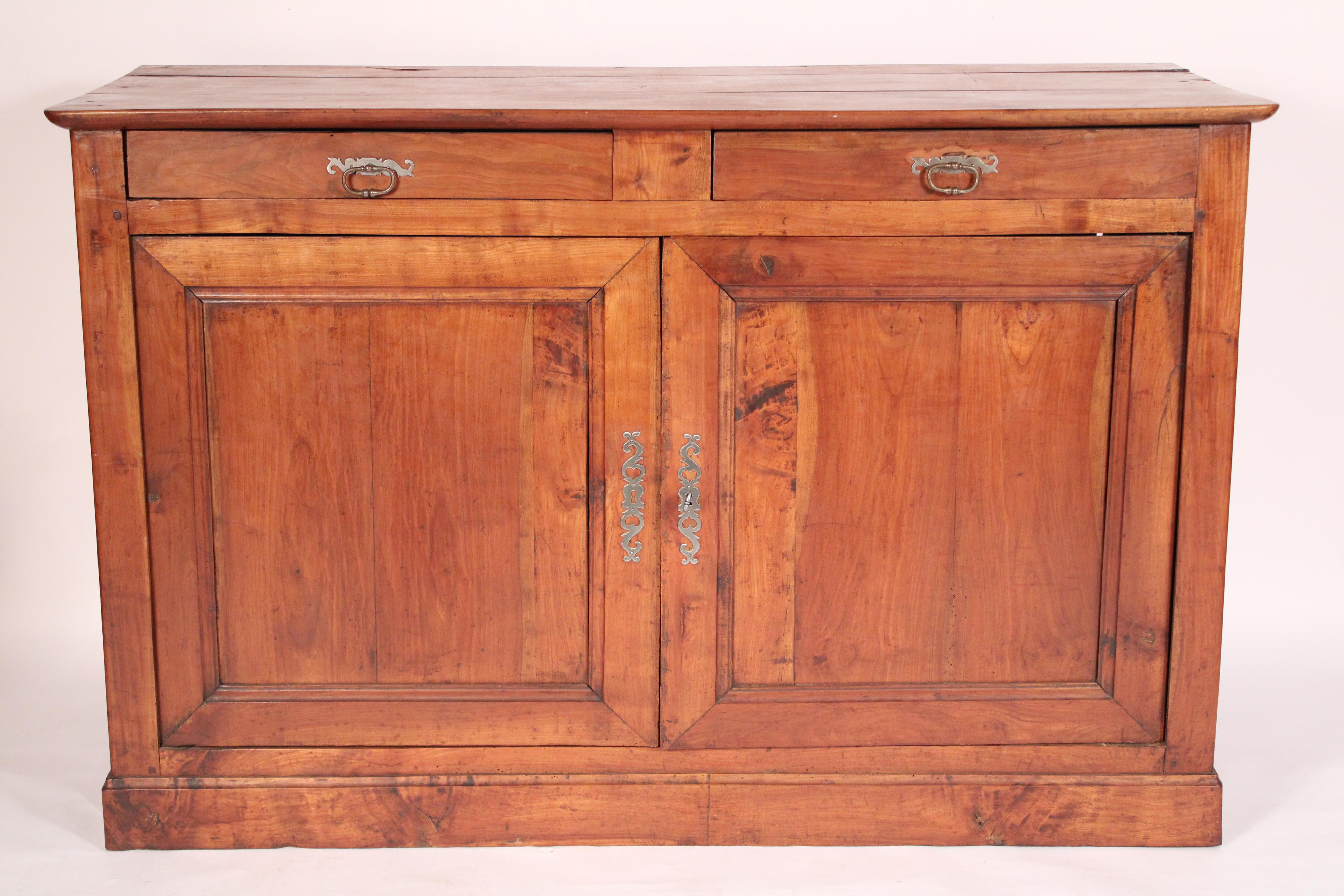 Buffet in legno di frutta Louis Philippe, XIX secolo. Con un piano rettangolare a 3 tavole, un fregio con due cassetti con tiretti in acciaio, due porte a pannelli con scure in acciaio, appoggiate su una base modanata. Costruzione dei cassetti a